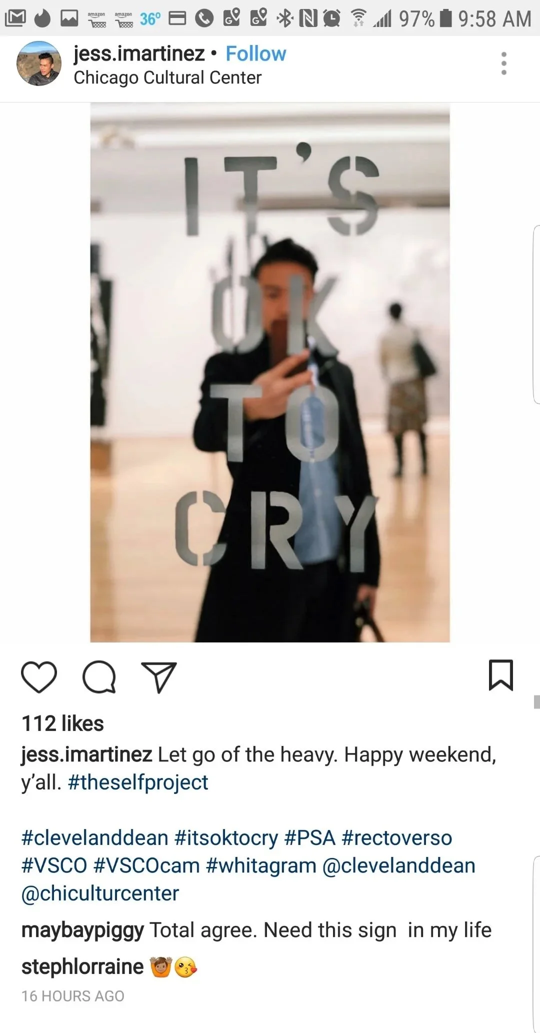 A person taking a mirror selfie at the Chicago Cultural Center. The mirror has words on it that say, "IT'S OK TO CRY," with the person's face visible through the reflection.