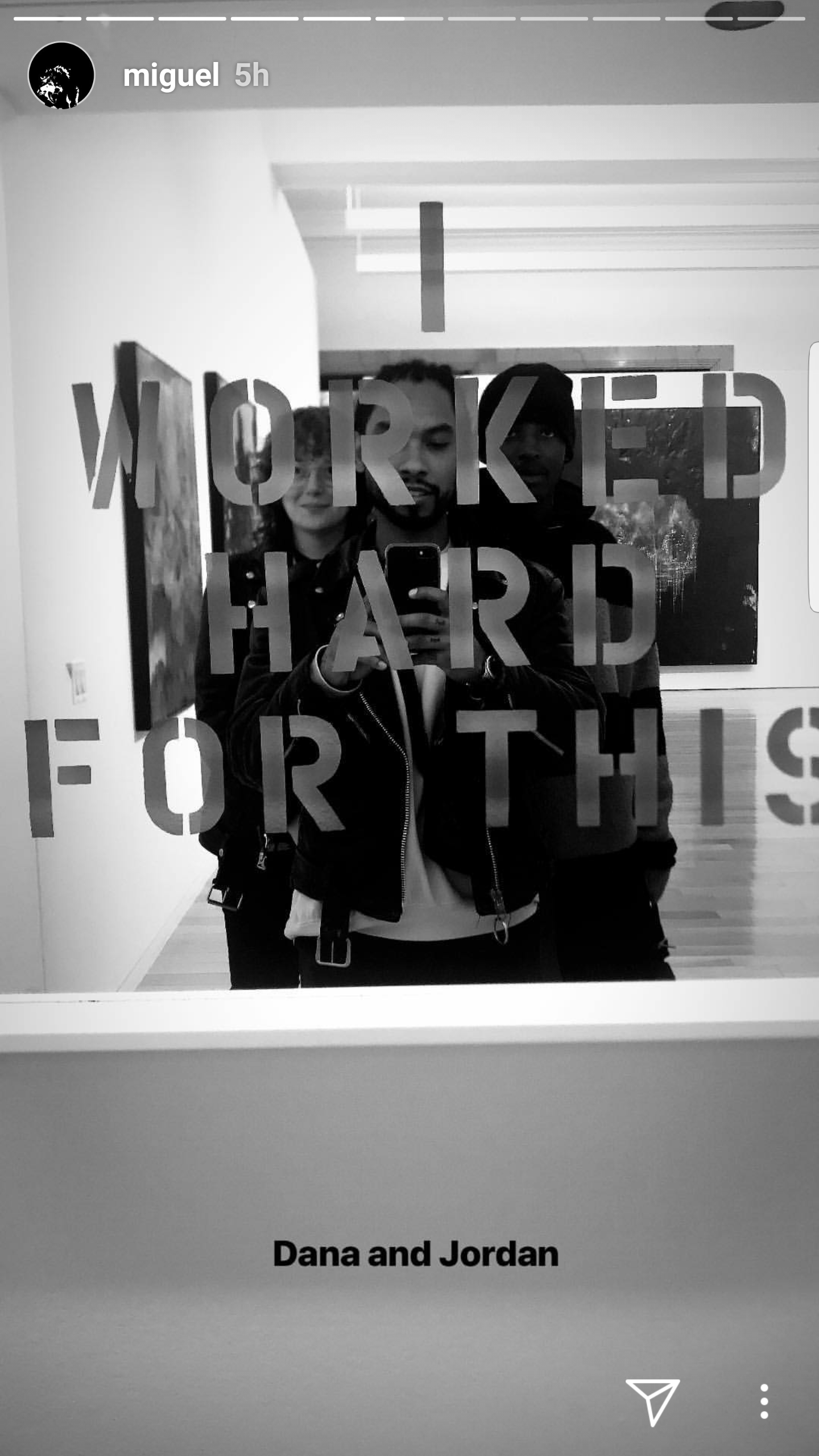 Three people taking a selfie in front of a mirror with the sign 'I WORKED HARD FOR THIS' displayed on it. The photo is in black and white. The names 'Dana and Jordan' are written below the image.