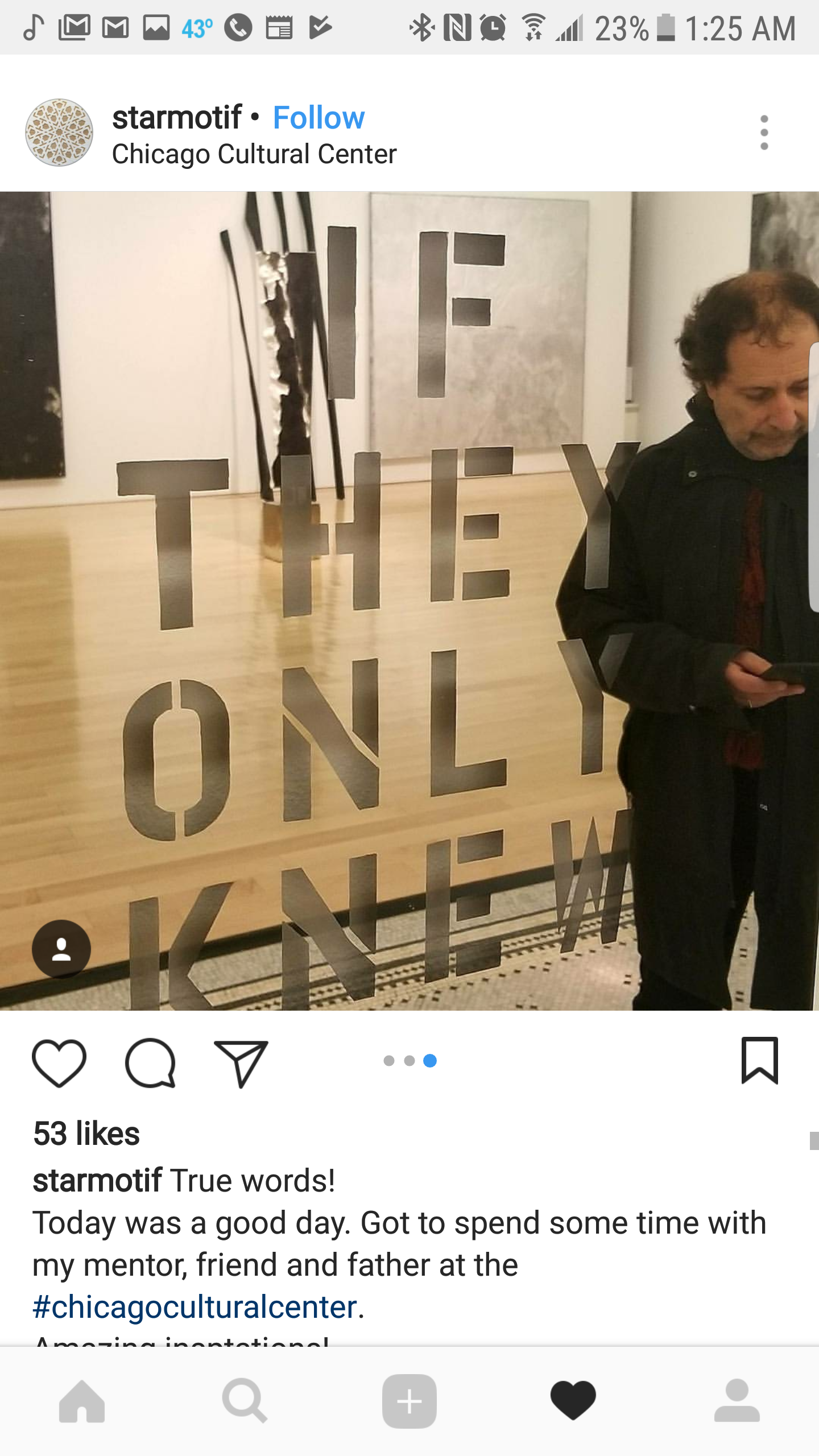 A reflection in a glass door with the words "If they only knew" written on it, showing a man with curly hair looking down and using his phone inside an art gallery, the Chicago Cultural Center.