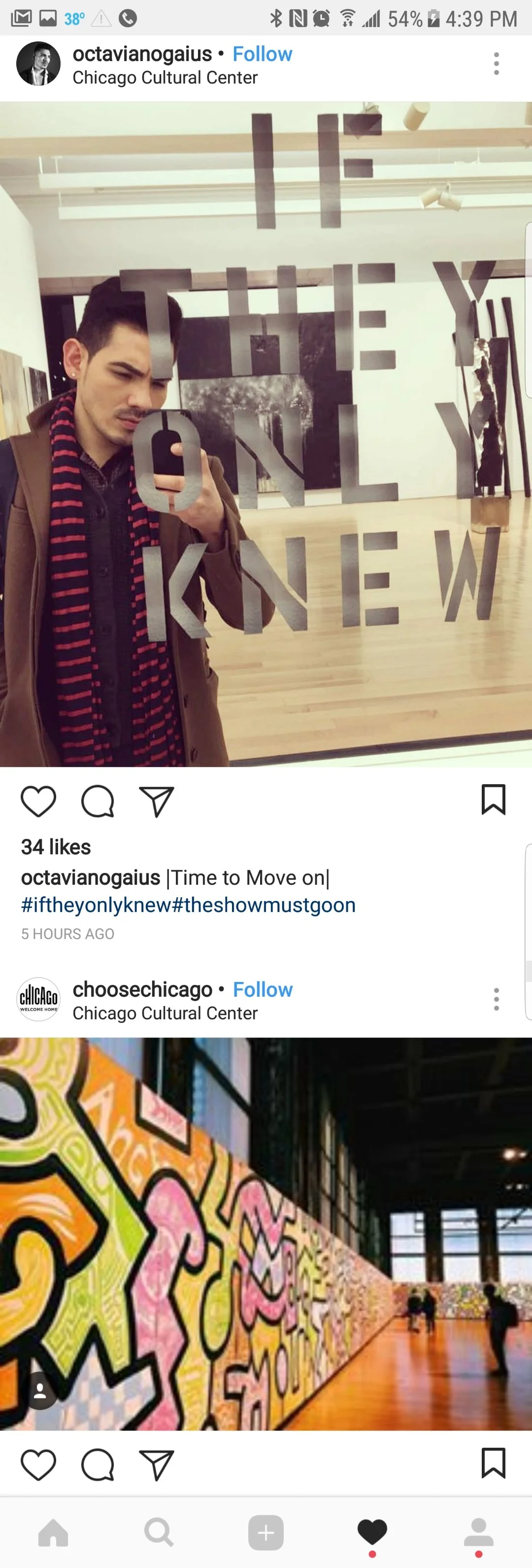 A young man taking a selfie in a mirror at the Chicago Cultural Center. The mirror has the words 'THE' and 'ONE' written on it.