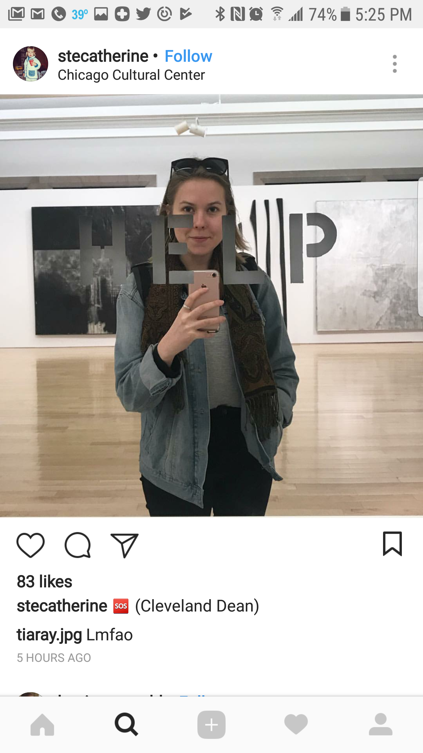 A woman taking a selfie in front of a mirror at the Chicago Cultural Center. She is wearing a denim jacket, sunglasses on her head, and a patterned scarf.