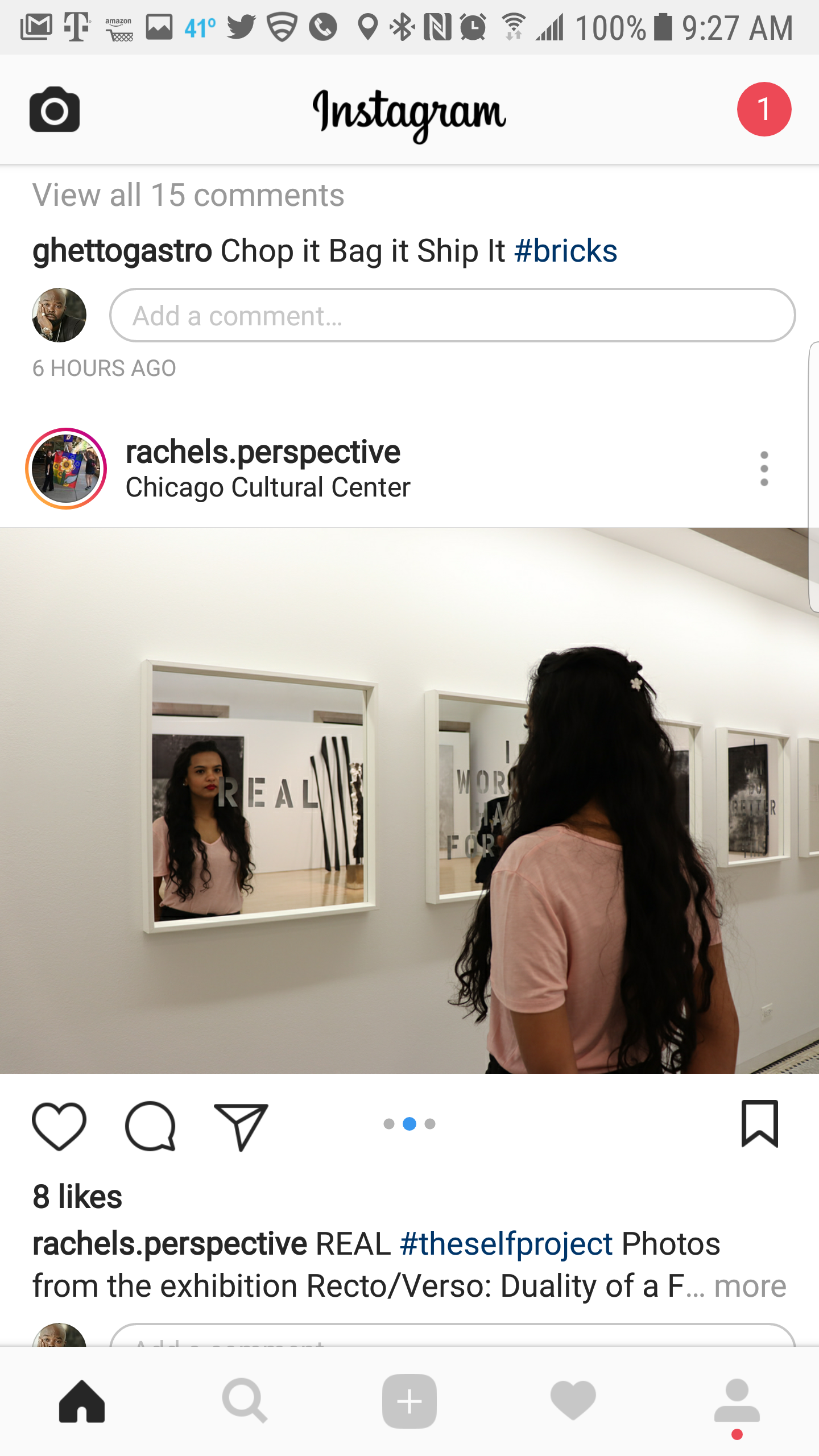 A woman with long dark wavy hair, wearing a pink shirt, looking at her reflection in framed mirrors on the wall of an art gallery.