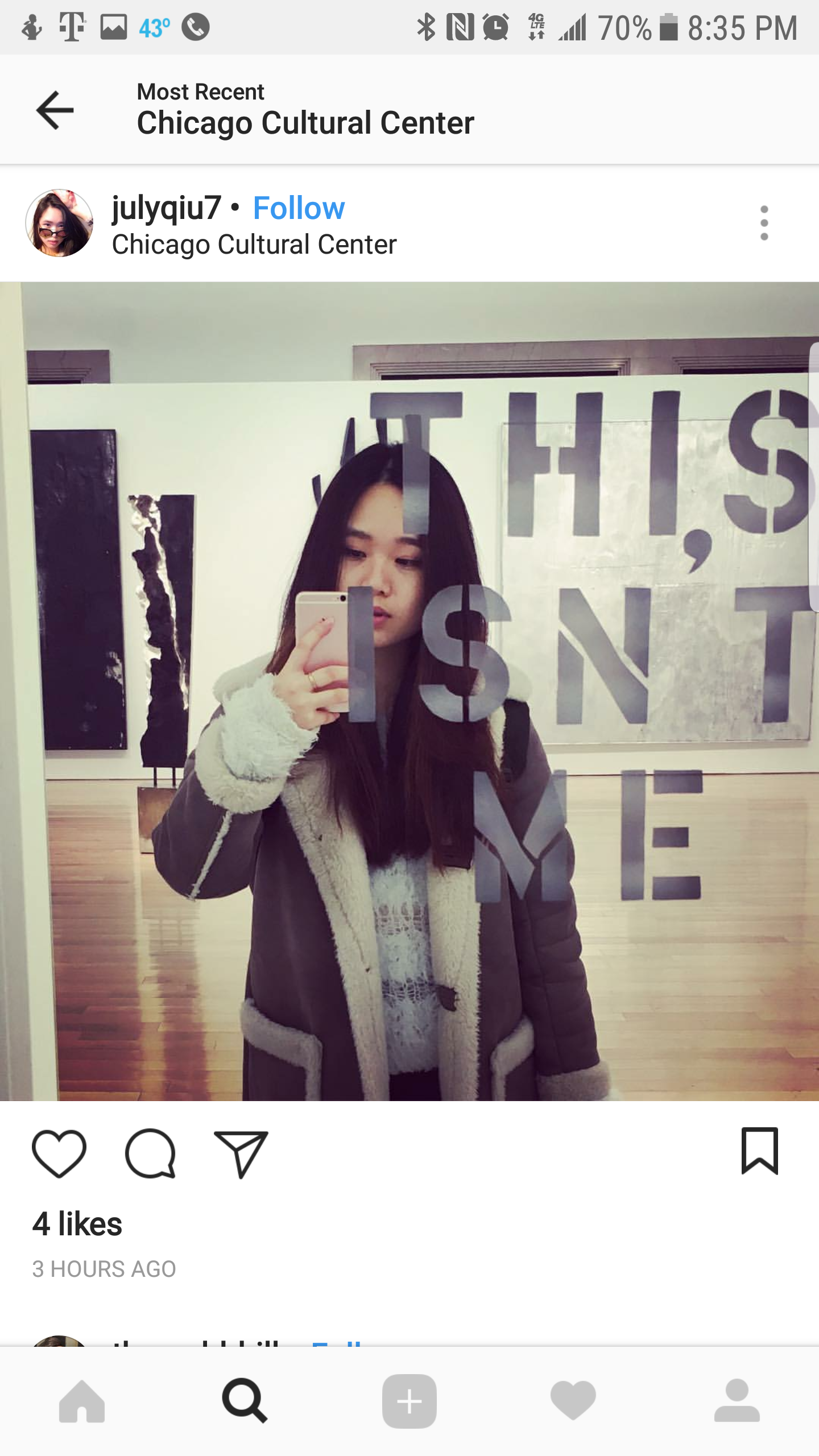 A young woman taking a mirror selfie at the Chicago Cultural Center, with text on the mirror that says 'THIS, SNT, ME'.
