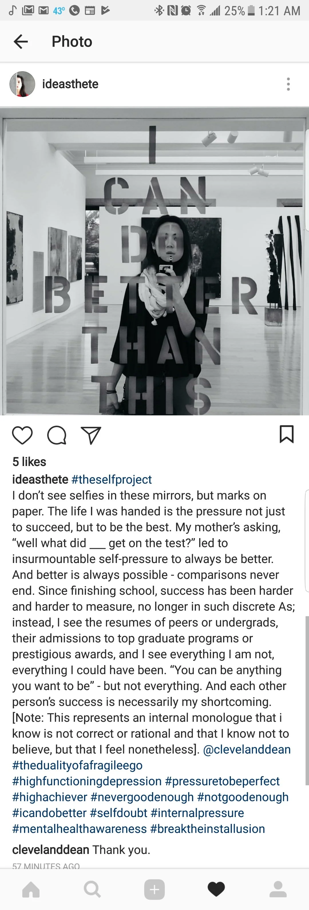 A woman taking a mirror selfie in an art gallery with text on the mirror that reads, "I CAN DO BETTER THAN THIS."