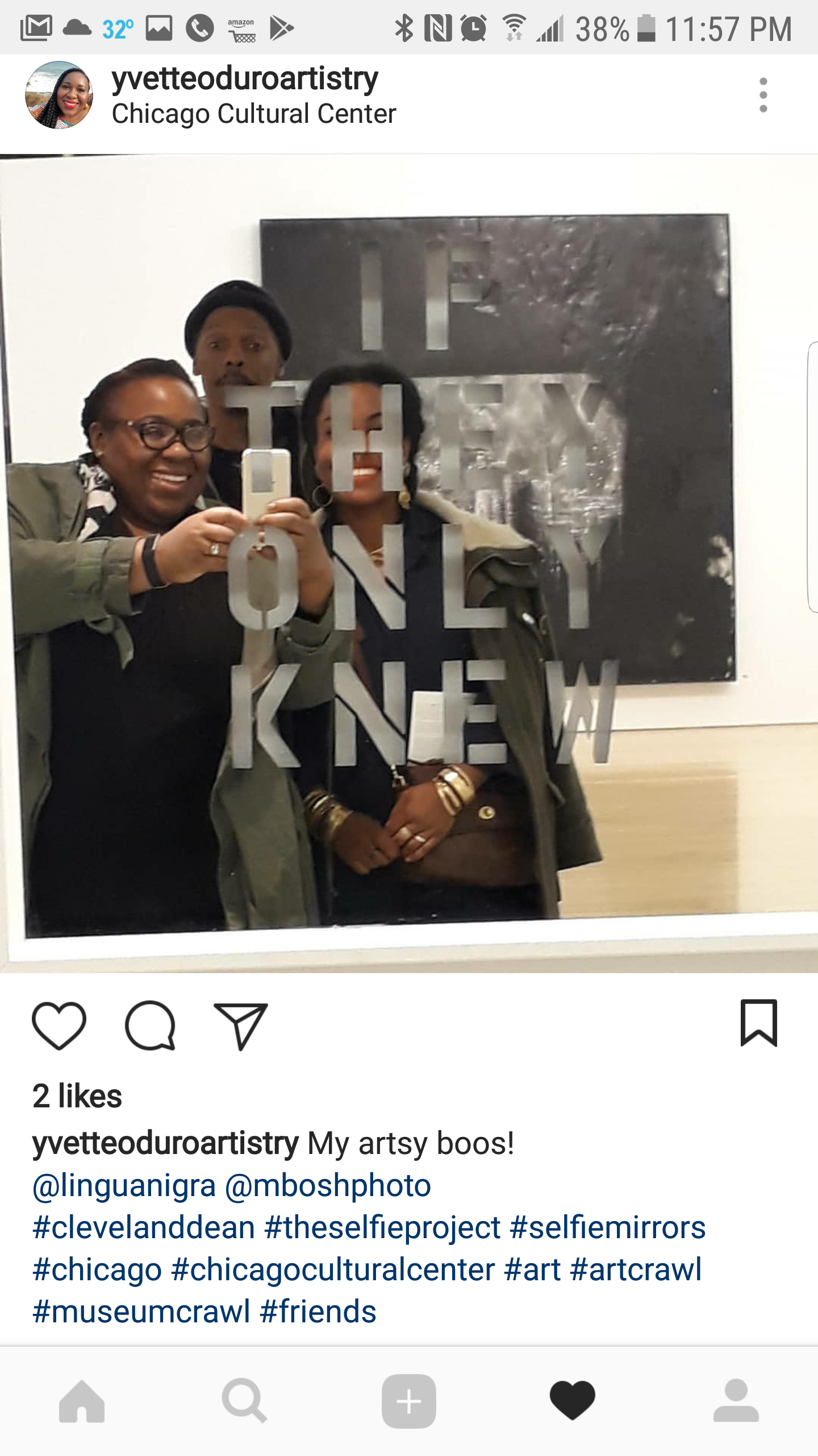 Three women and one man taking a mirror selfie at the Chicago Cultural Center. They are smiling, with the mirror having the words 'The Art of Being New' written on it. Background includes a black and white artwork.