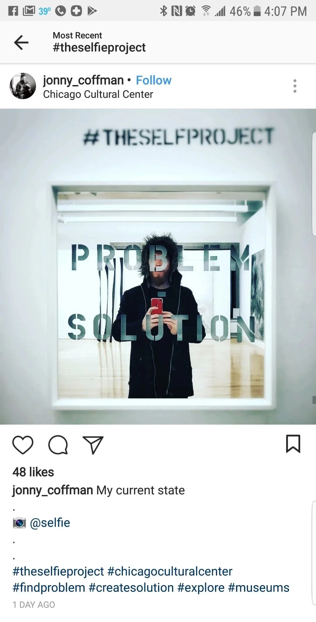 A person taking a selfie in a mirror at the Chicago Cultural Center, with text on the mirror reading 'PROBLEM SOLUTION'.