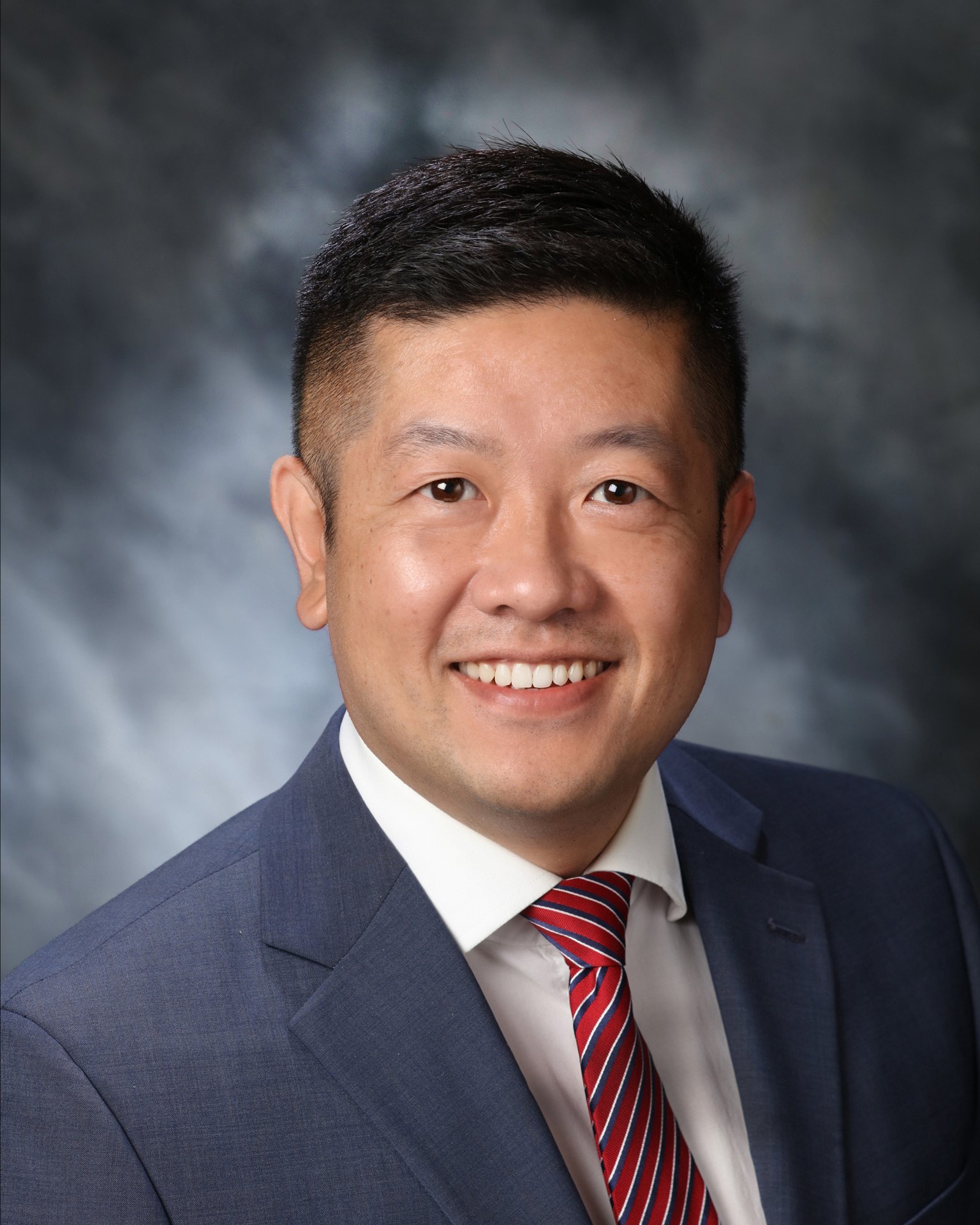 corporate headshot for male bank manager with gray studio background. 