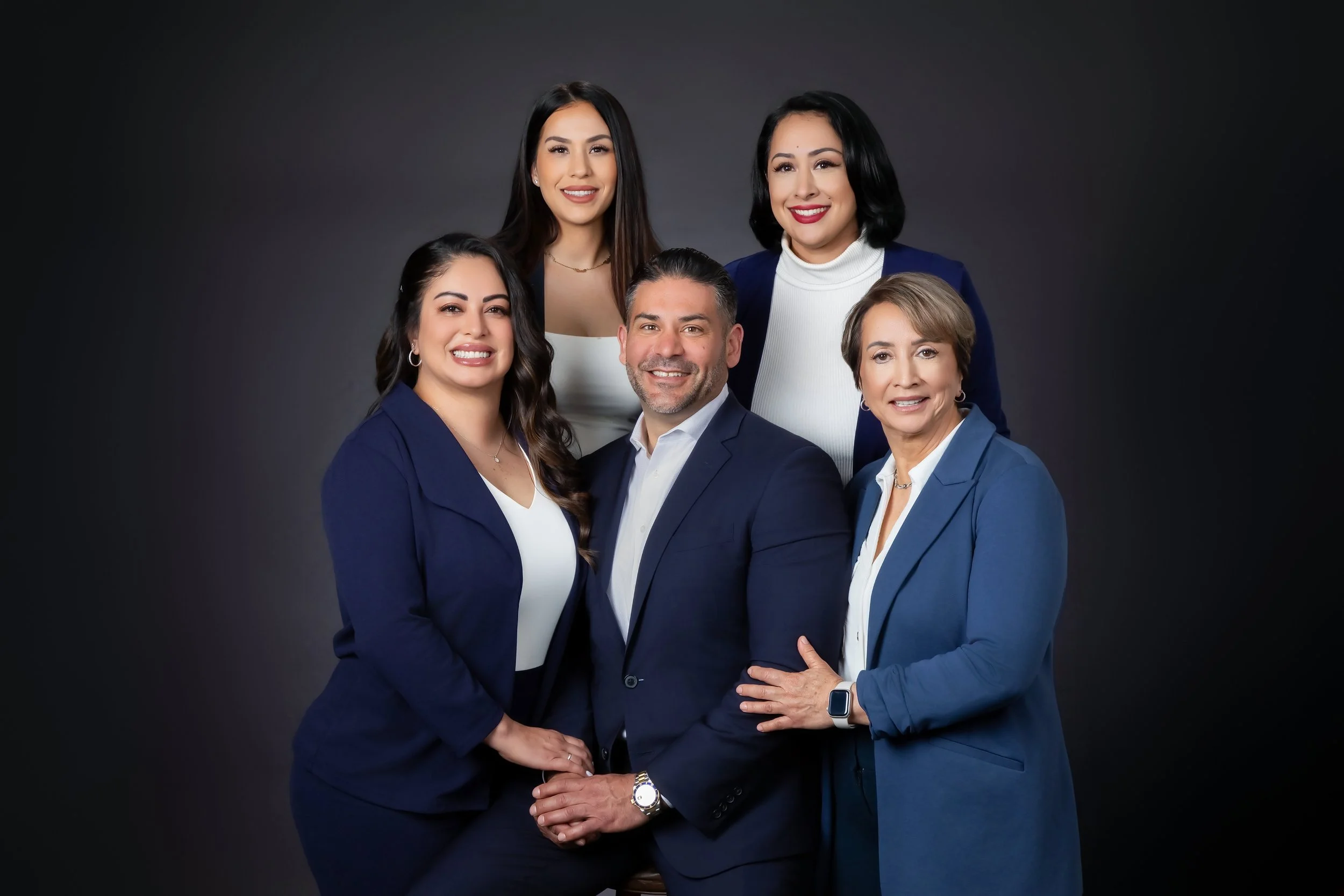 formal team photo on black studio background for a small family-run business.