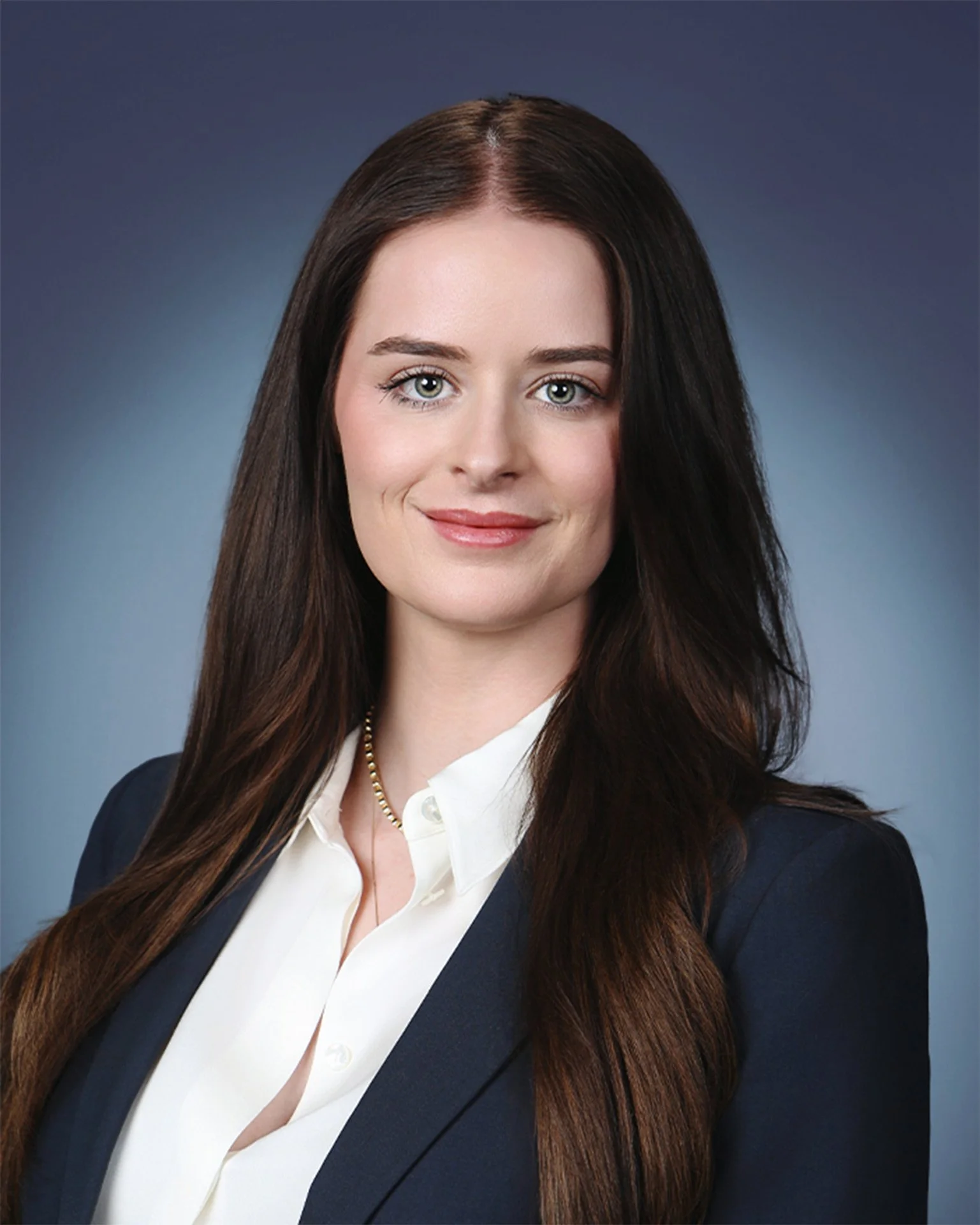 female professional headshot with blue studio background.