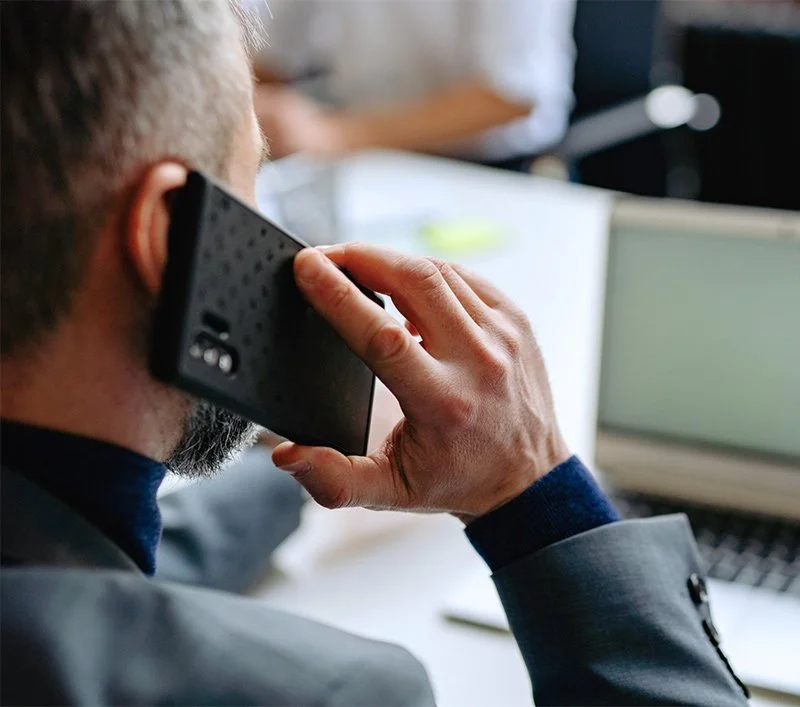A man with a beard talking on a phone with best local tax preparer and financial planner at Winn Financials & Tax Services in Redding, CA