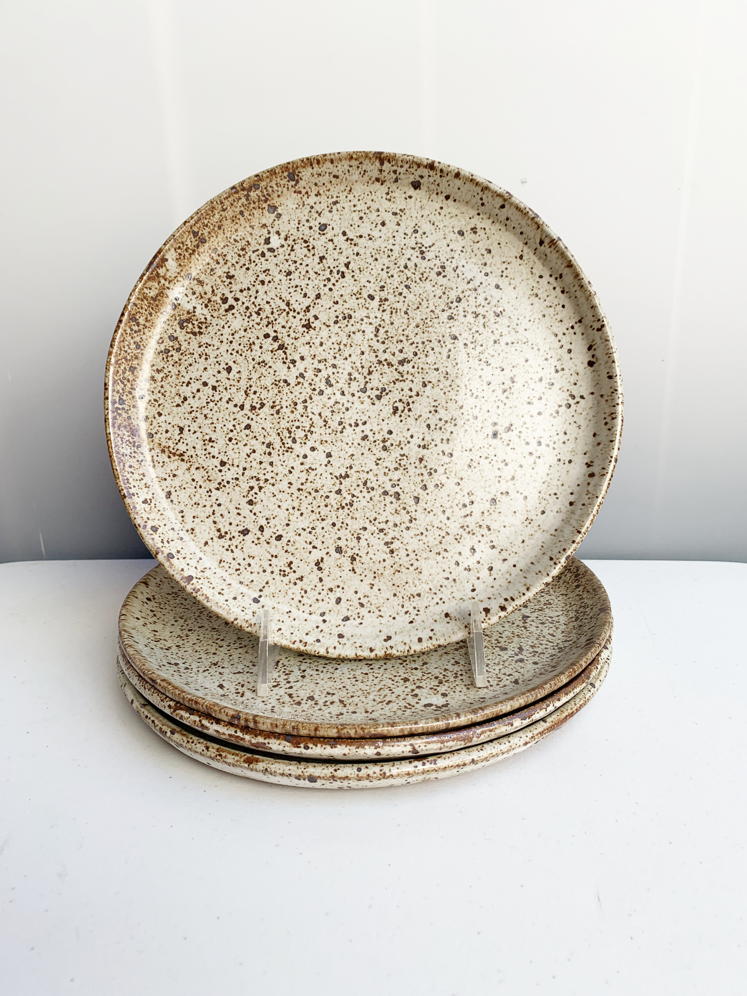 Handmade stoneware dinner plate with a soft gray speckled glaze and warm brown flecks.