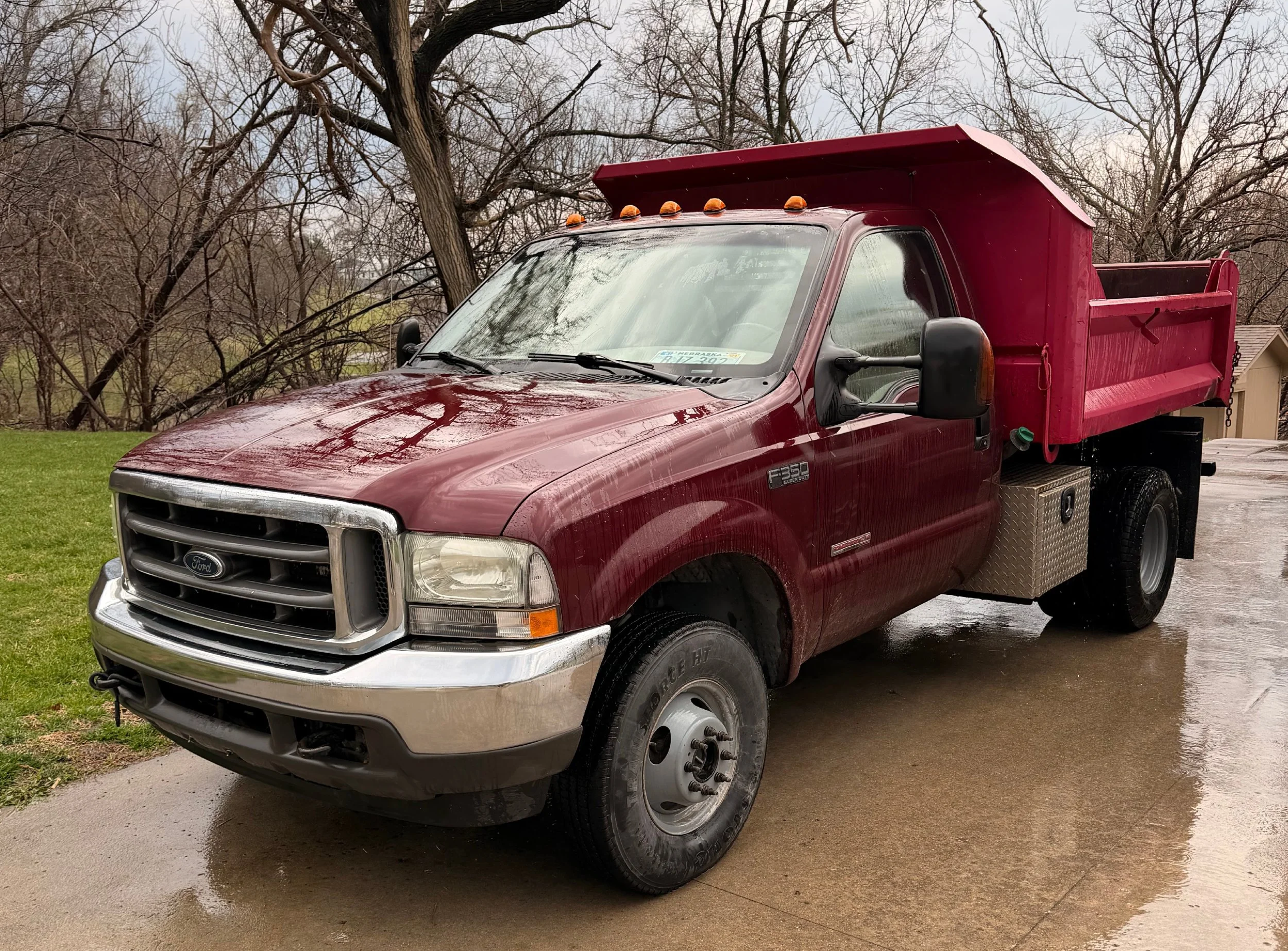 The truck used for Big Dog Hauling and Junk Removal is parked outside. The truck's red cab is visible, along with its big dump bed. Contact Big Dog Hauling and Junk Removal for all of your hauling and junk disposal needs. Let us do the work for you!