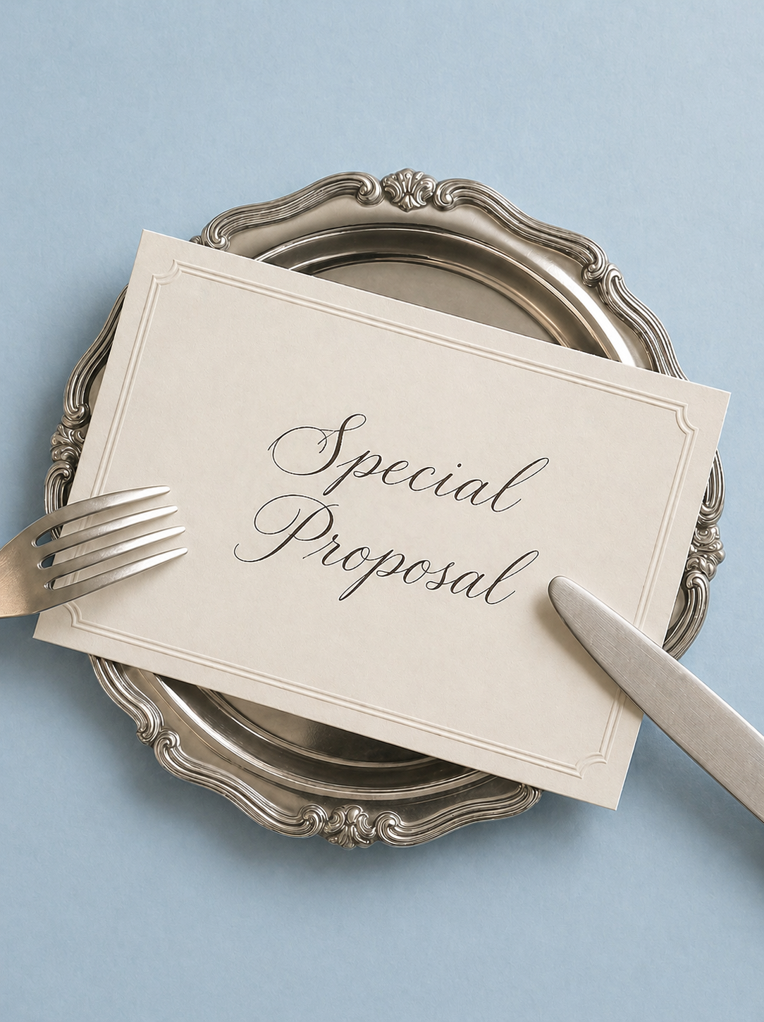 A silver tray holding a card with the words 'Special Proposal' written in cursive, with a fork and knife on each side, on a light blue background.
