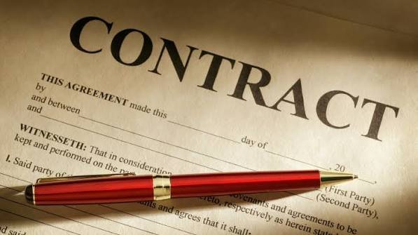 Close-up of a contract document with a red pen placed on top.