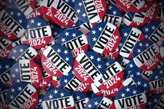 Collection of political campaign buttons with 'VOTE 2024' and stars in red, white, and blue colors.