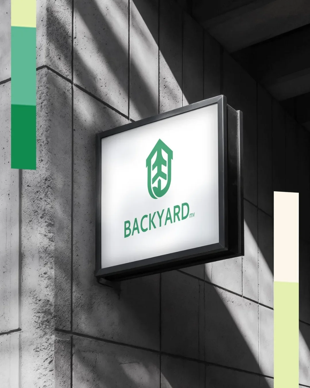 Backyard logo on a backlit sign mounted on a concrete wall, with shadows cast on the wall.