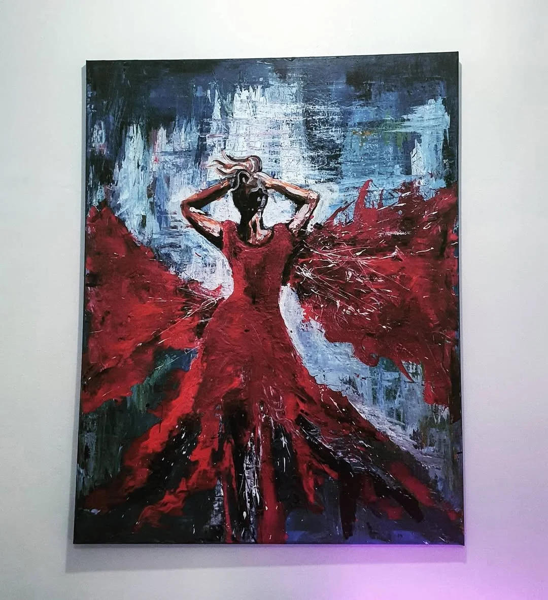 An abstract painting of a woman wearing a flowing red dress with butterfly-like wings, holding her hair, with a blue and white background.
