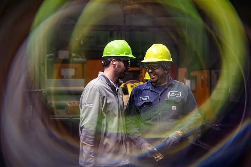Two manufacturing professionals collaborating inside a modern foundry.