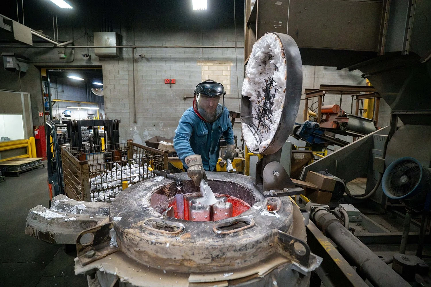 Manufacturing operator monitoring an automated metalcasting machine.
