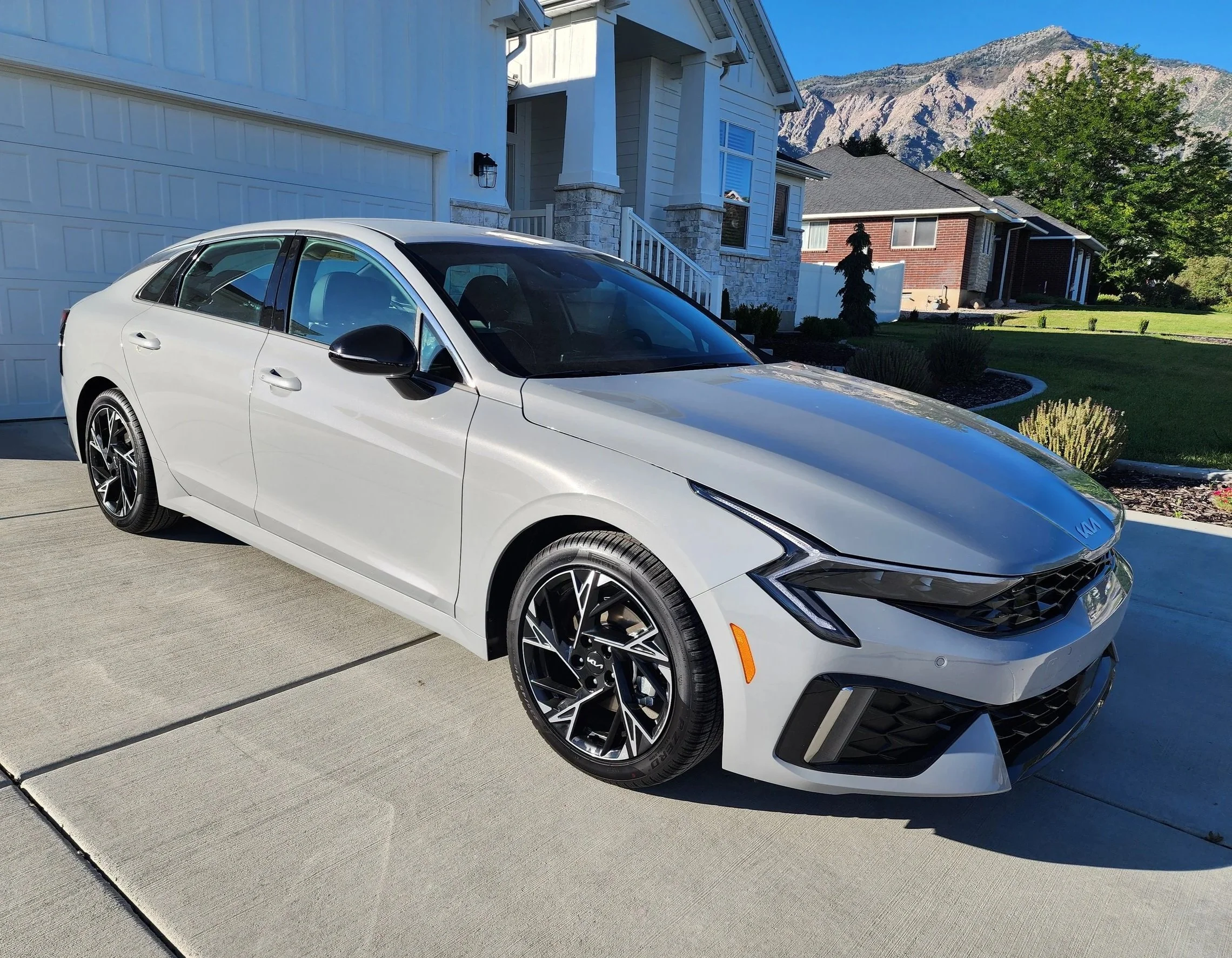 Wolf Grey KIA K5 freshly detailed exterior sitting in a residential driveway — mobile car detailing service in Utah by Scrub Tub