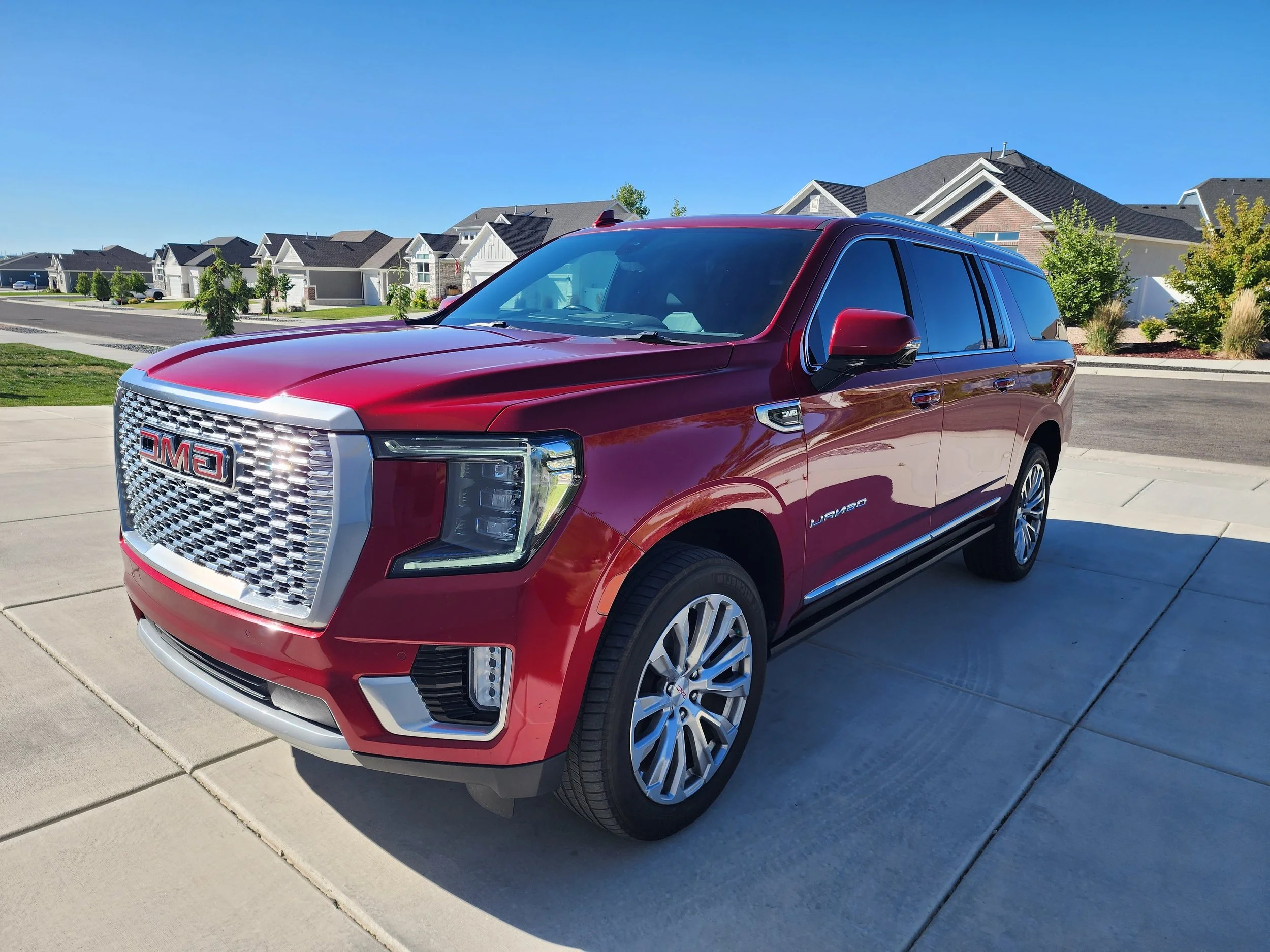 Red GMC Yukon XL Denali gleaming after professional exterior detail, parked in a residential driveway — mobile car detailing by Scrub Tub in Utah