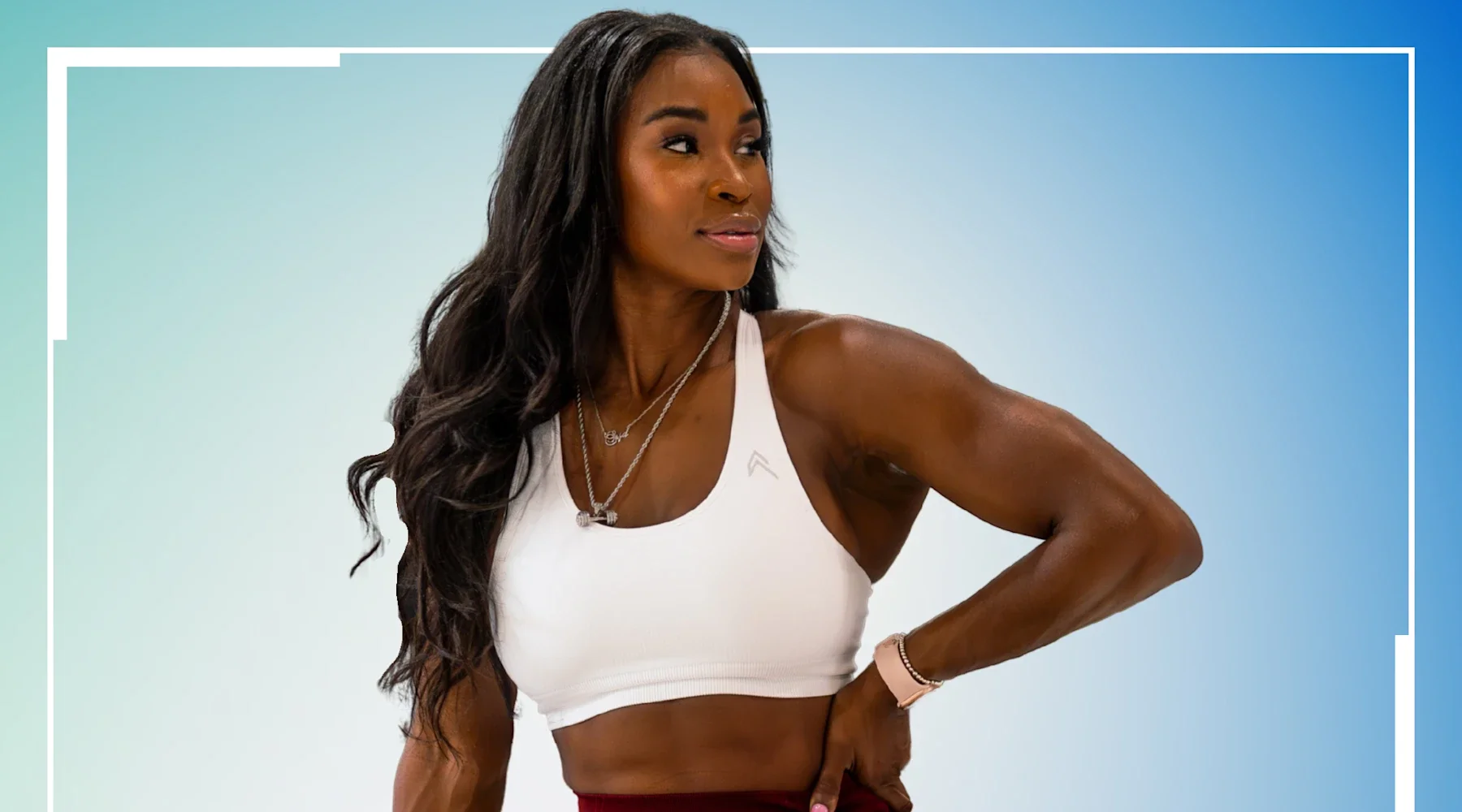 A woman with long wavy black hair, wearing a white sports bra and red leggings, looks to her left with one hand on her waist against a light gradient background with white borders.
