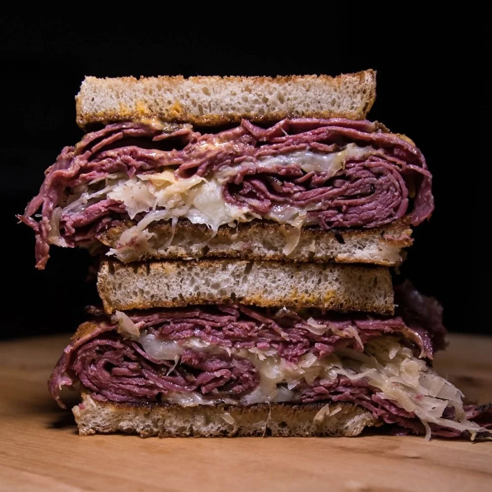 Stacked slices of corned beef on rye bread with sauerkraut.