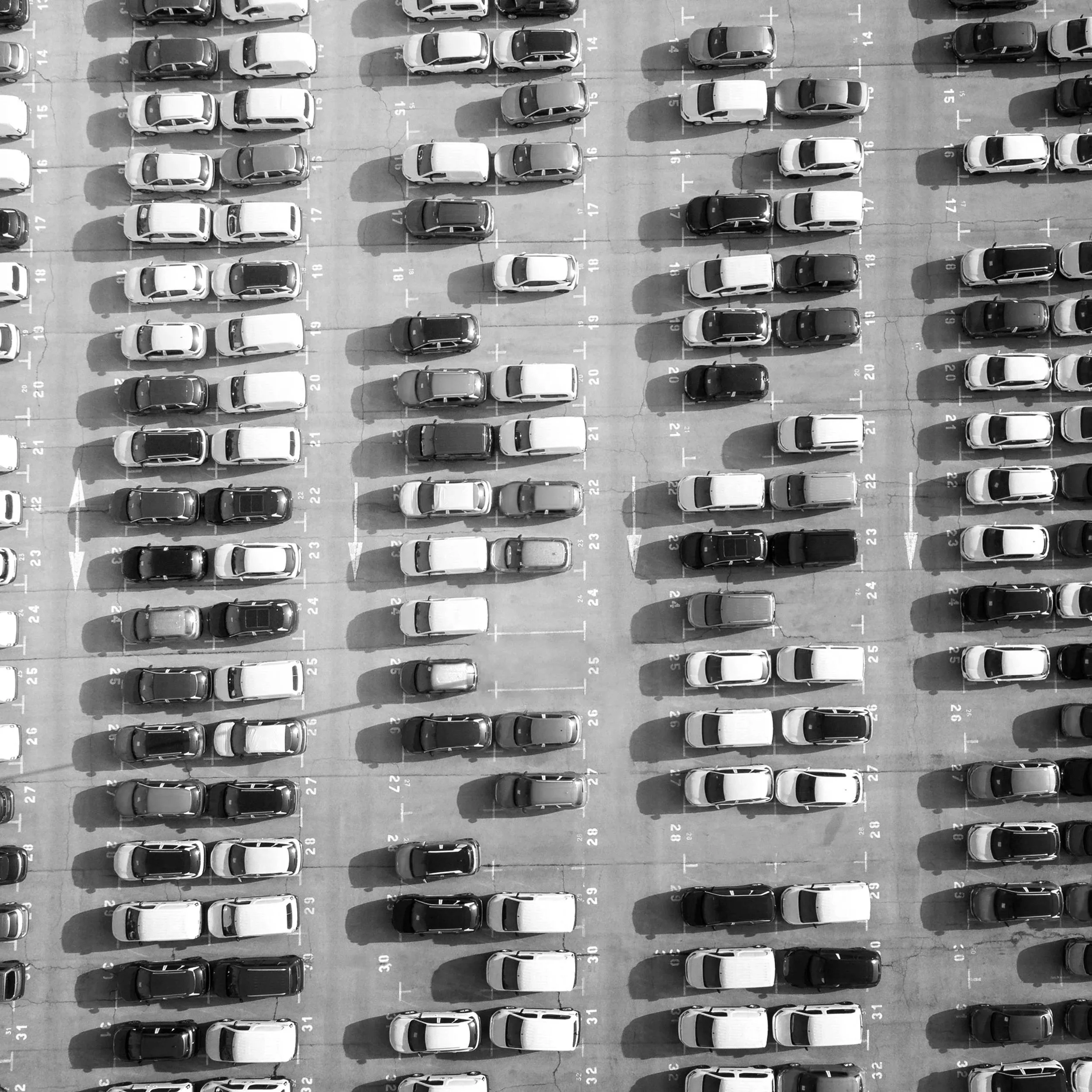 An aerial view of a secure parking lot in Christchurch filled with rows of cars parked in numbered parking spaces.