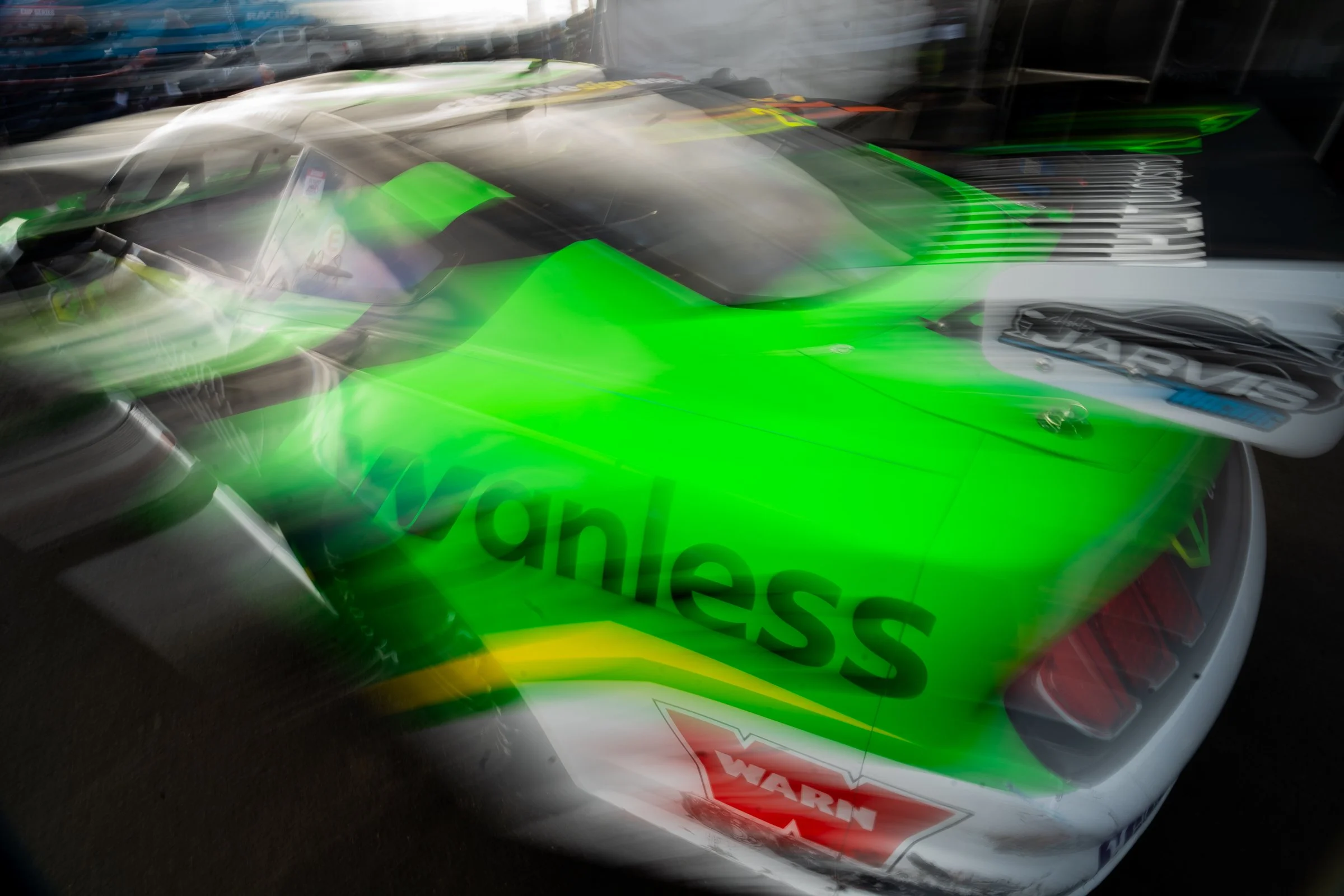Bright green race car with black and white graphics captured in a blurred motion shot