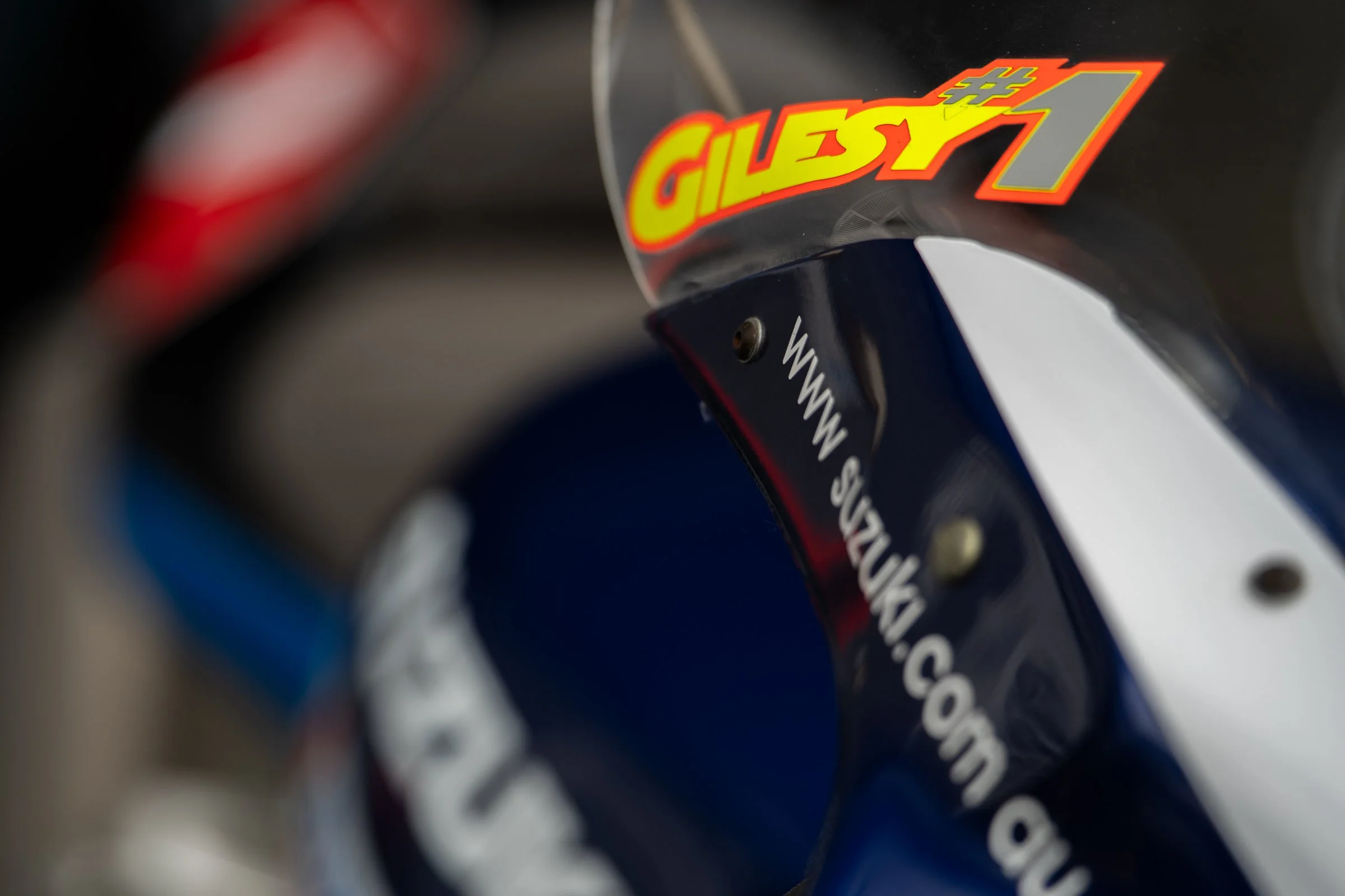 Close‑up of a racing motorcycle with GILESY #1 branding and a visible website URL