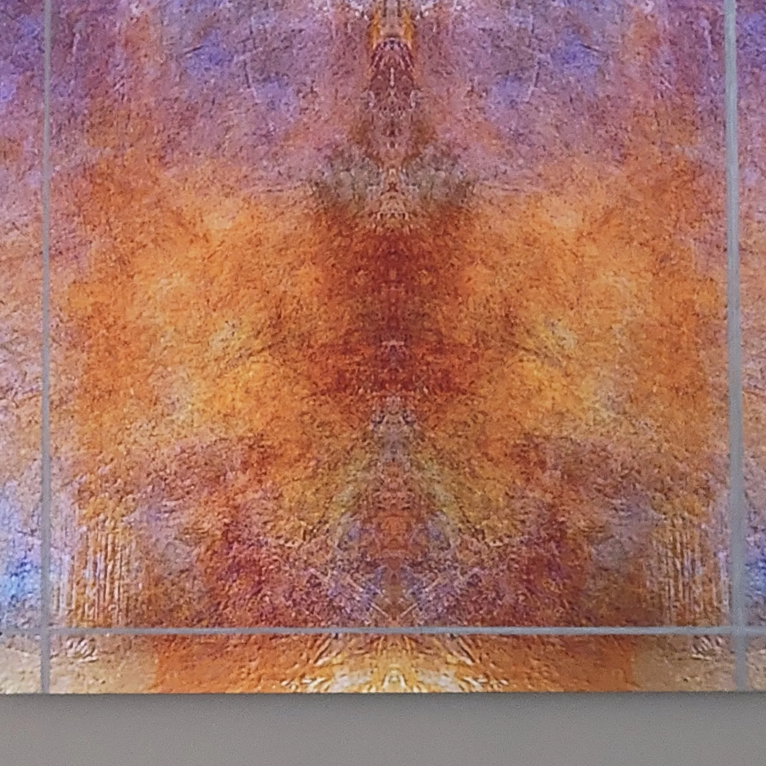 An abstract artwork with swirling and textured patterns in shades of orange, purple, pink, and beige, framed by a simple border.