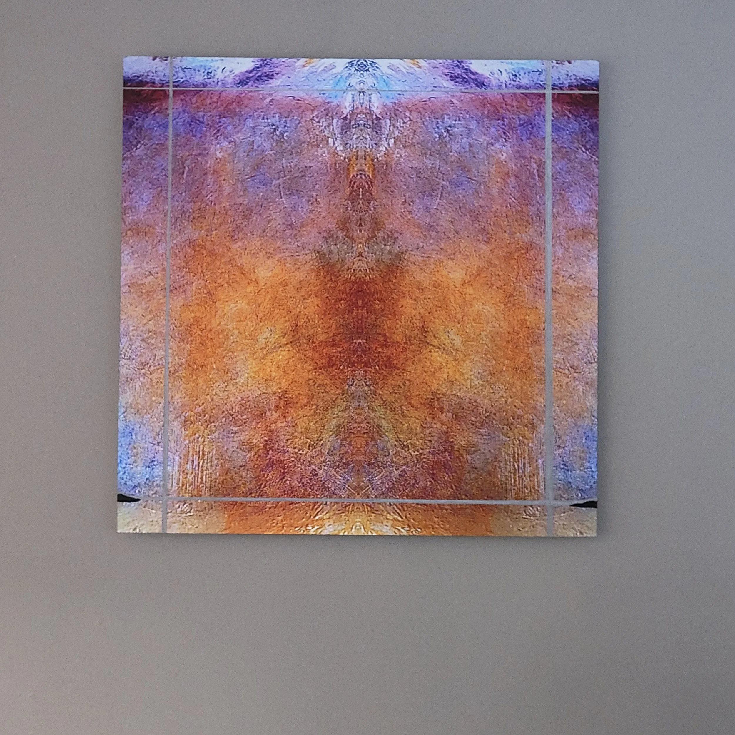 Abstract artwork with bright colors including purple, orange, and blue, displayed on a dark wall.