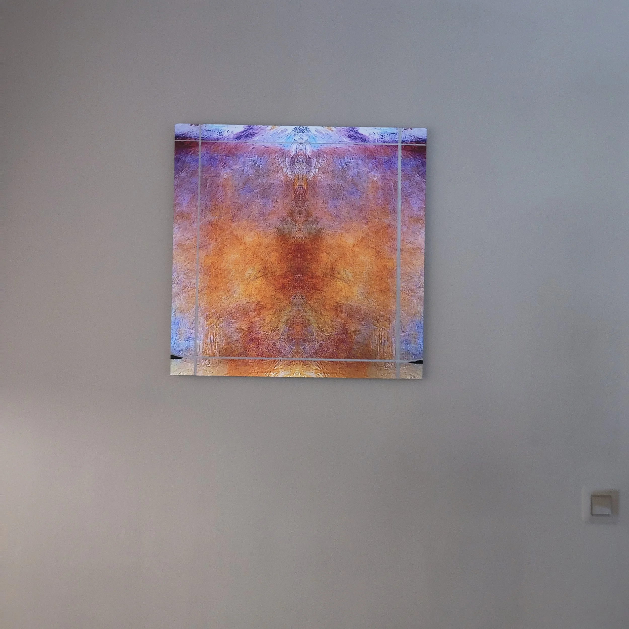 Partial view of abstract colorful artwork on a gray wall.