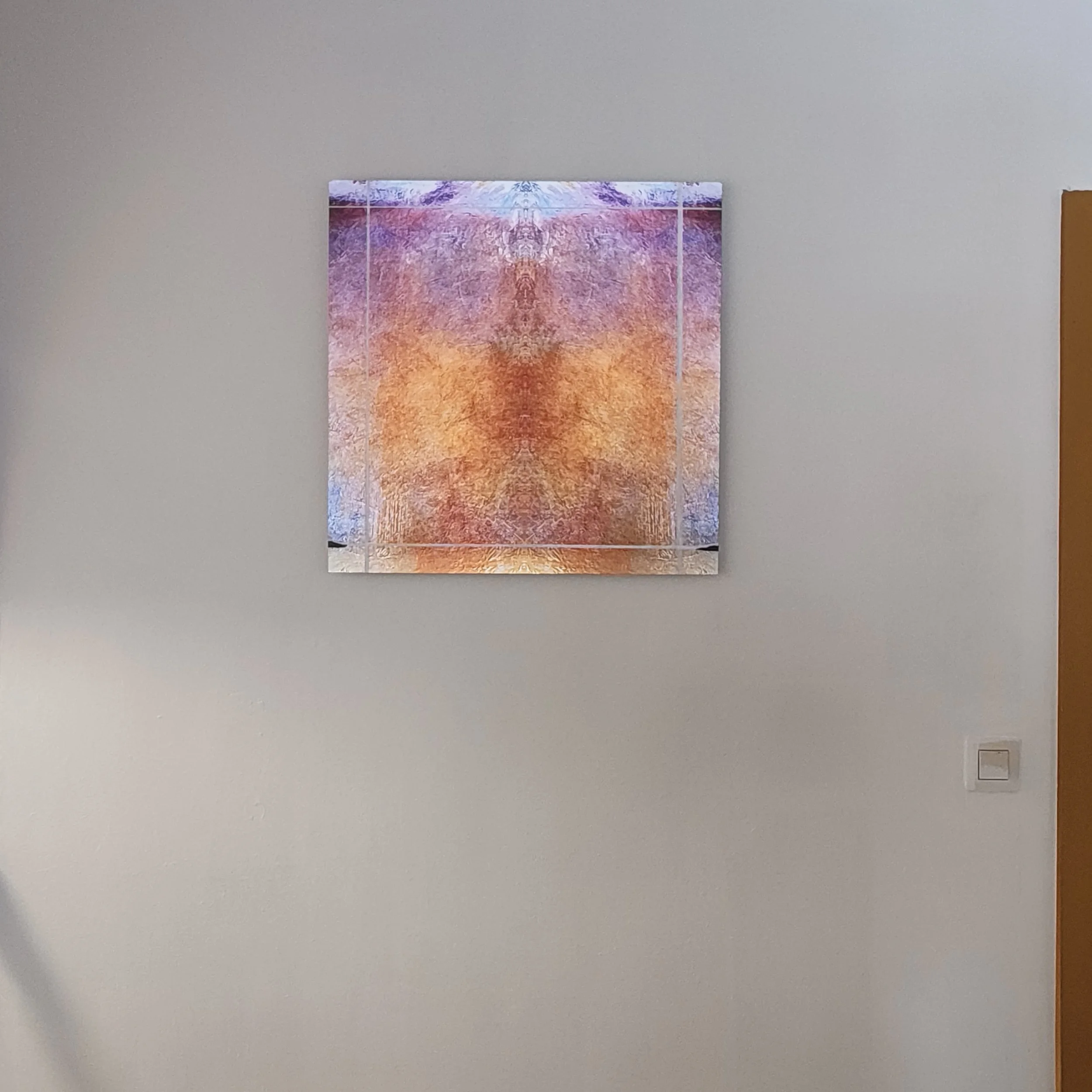A colorful abstract artwork on a wall with geometric lines, blending pink, purple, orange, and blue hues, illuminated by overhead lighting.