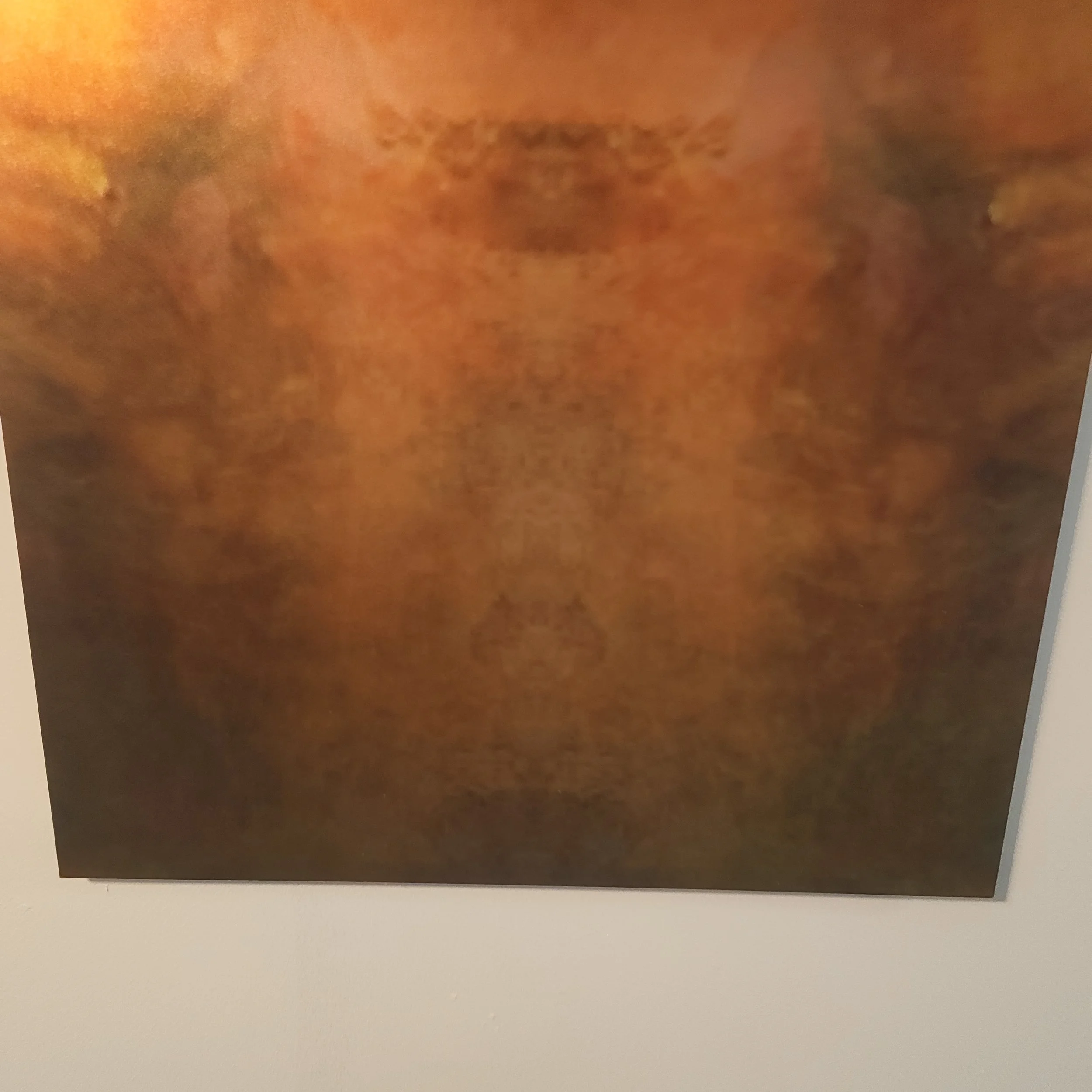 Close-up of a textured surface with a horizontal mark in the center, in shades of orange and brown.