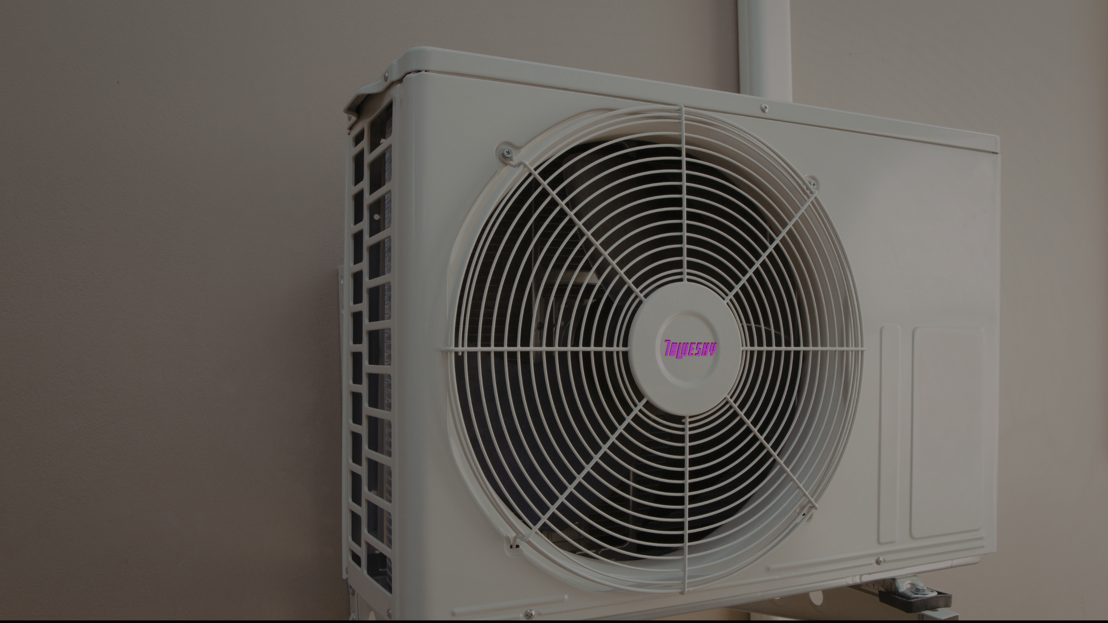 An outdoor air conditioning unit mounted on a wall with a protective grille over the fan and a digital display showing the text '1bQUE5H'.