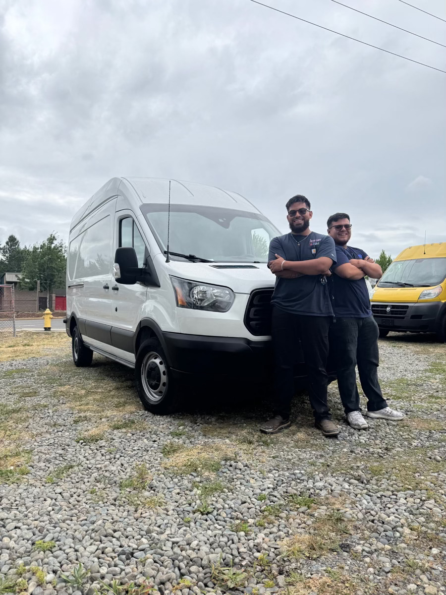 Angel and Omar, founders of 7BlueSky Heating & Air, standing in front of a service van in the Tri-Cities