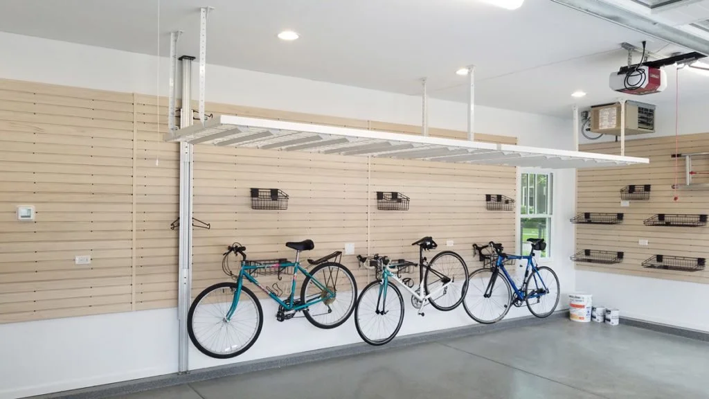 Empty garage with three parked bikes and wall-mounted shelves.