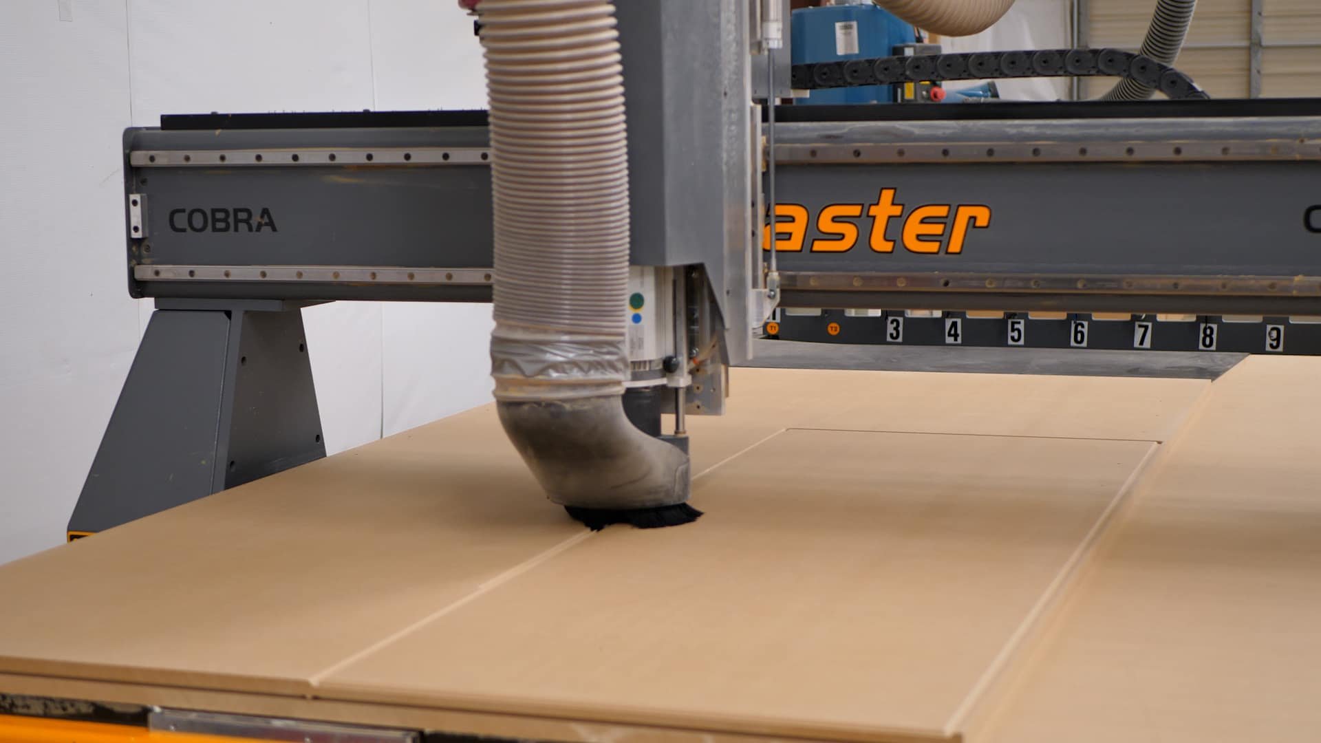 A CNC laser cutting machine cutting wood panels.