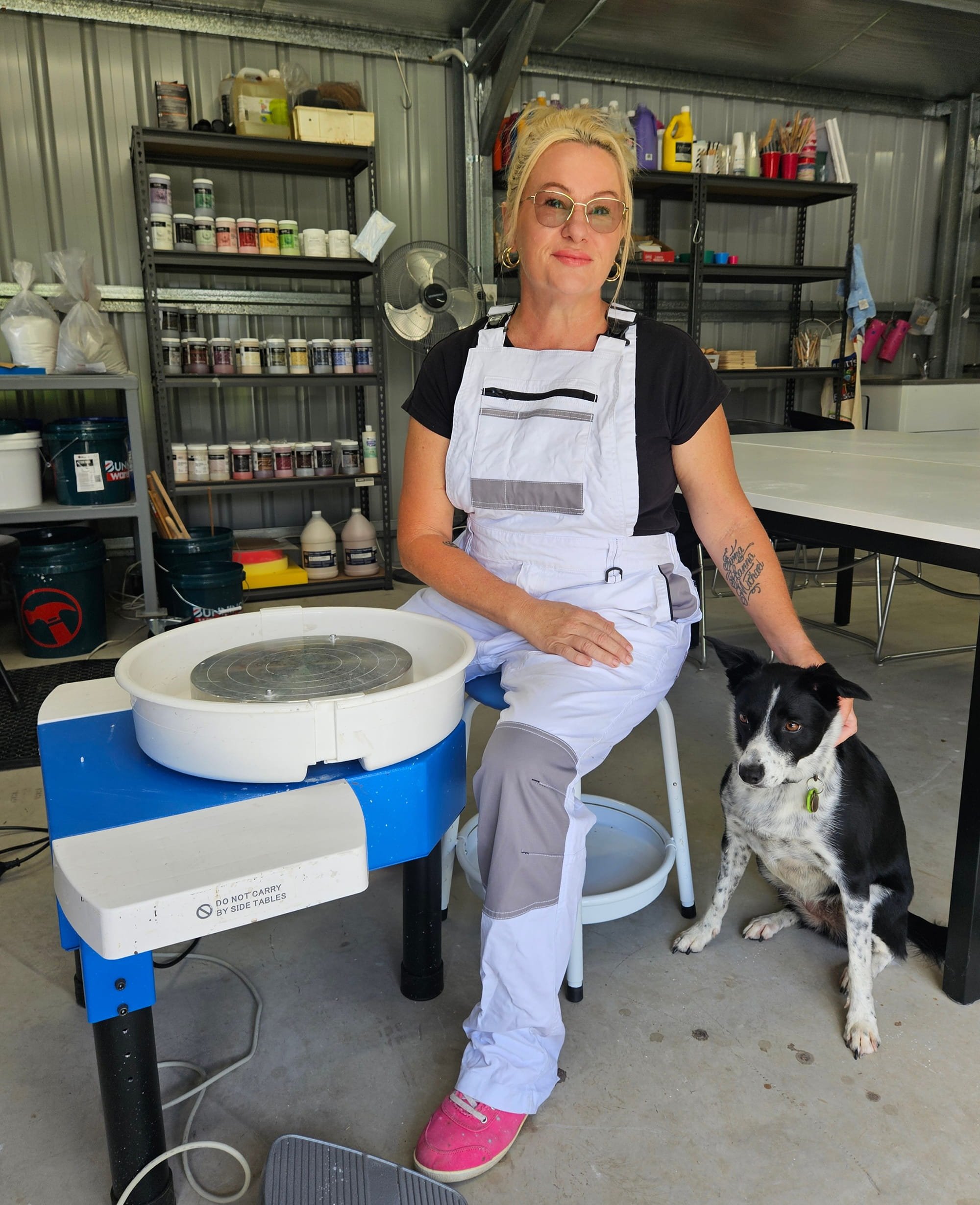 Pottery maker with dog in creative studio environment
