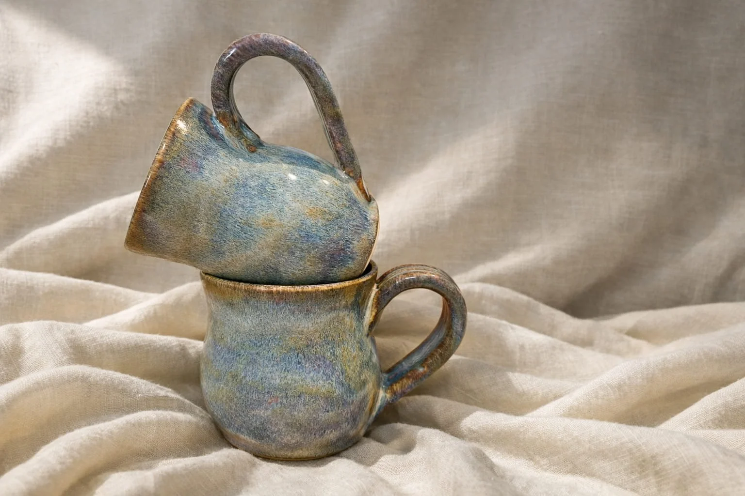 Handmade ceramic mugs in soft natural light