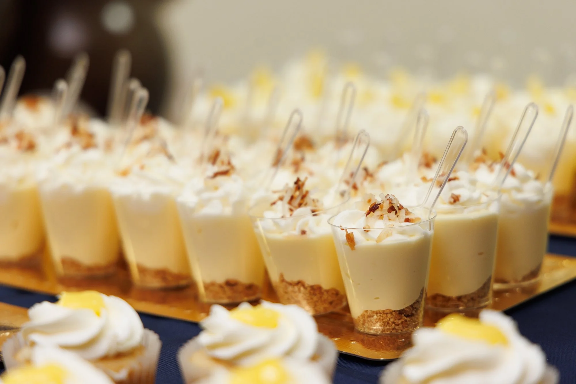 Individual dessert shooters topped with whipped cream and chocolate garnish prepared by Bites We Like in Nassau, Bahamas.