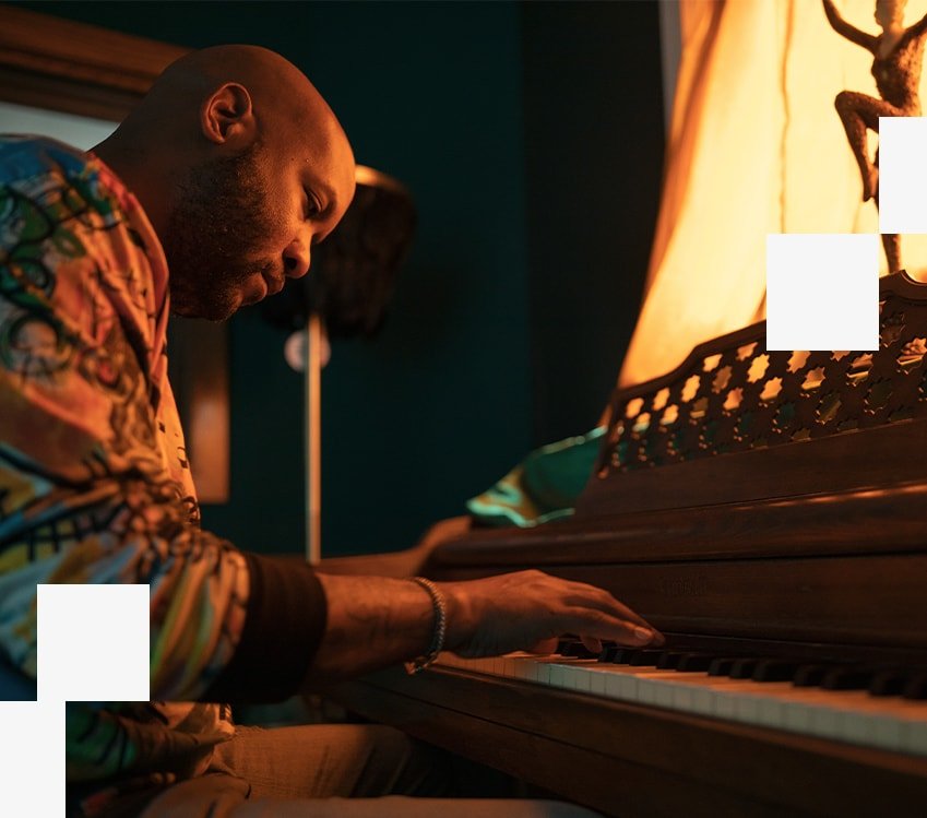 Man playing the piano in a dimly lit room.