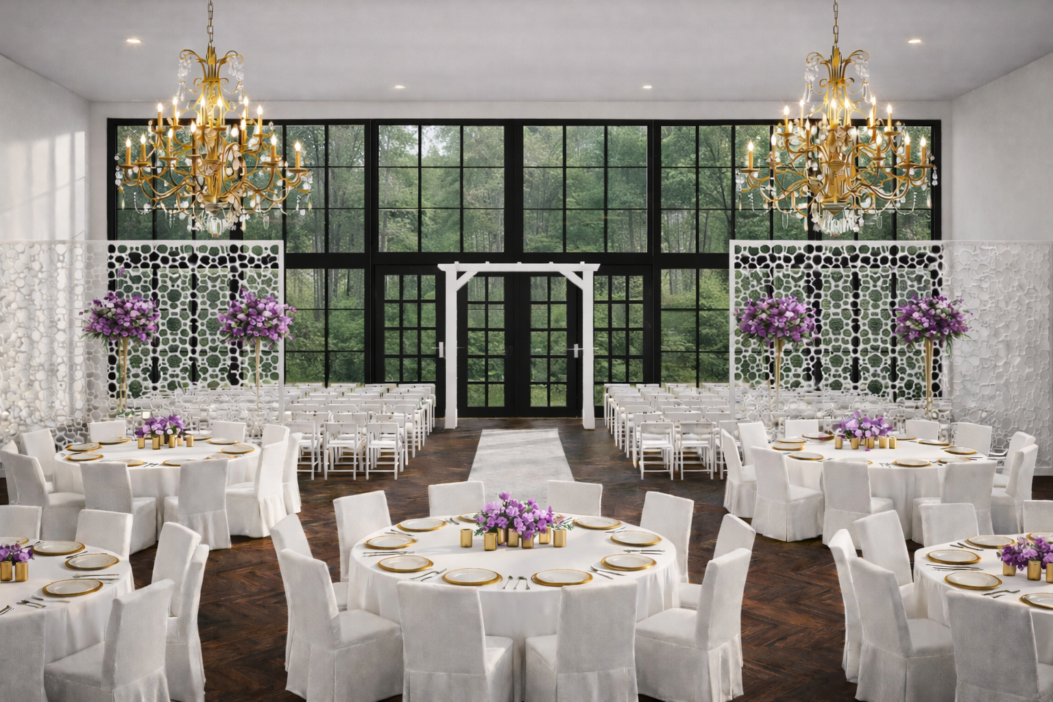 Elegant wedding reception hall with round tables covered in white tablecloths, purple floral centerpieces, gold accents on plates, and gold chandeliers hanging from the ceiling. Large windows reveal a wooded outdoor scene.
