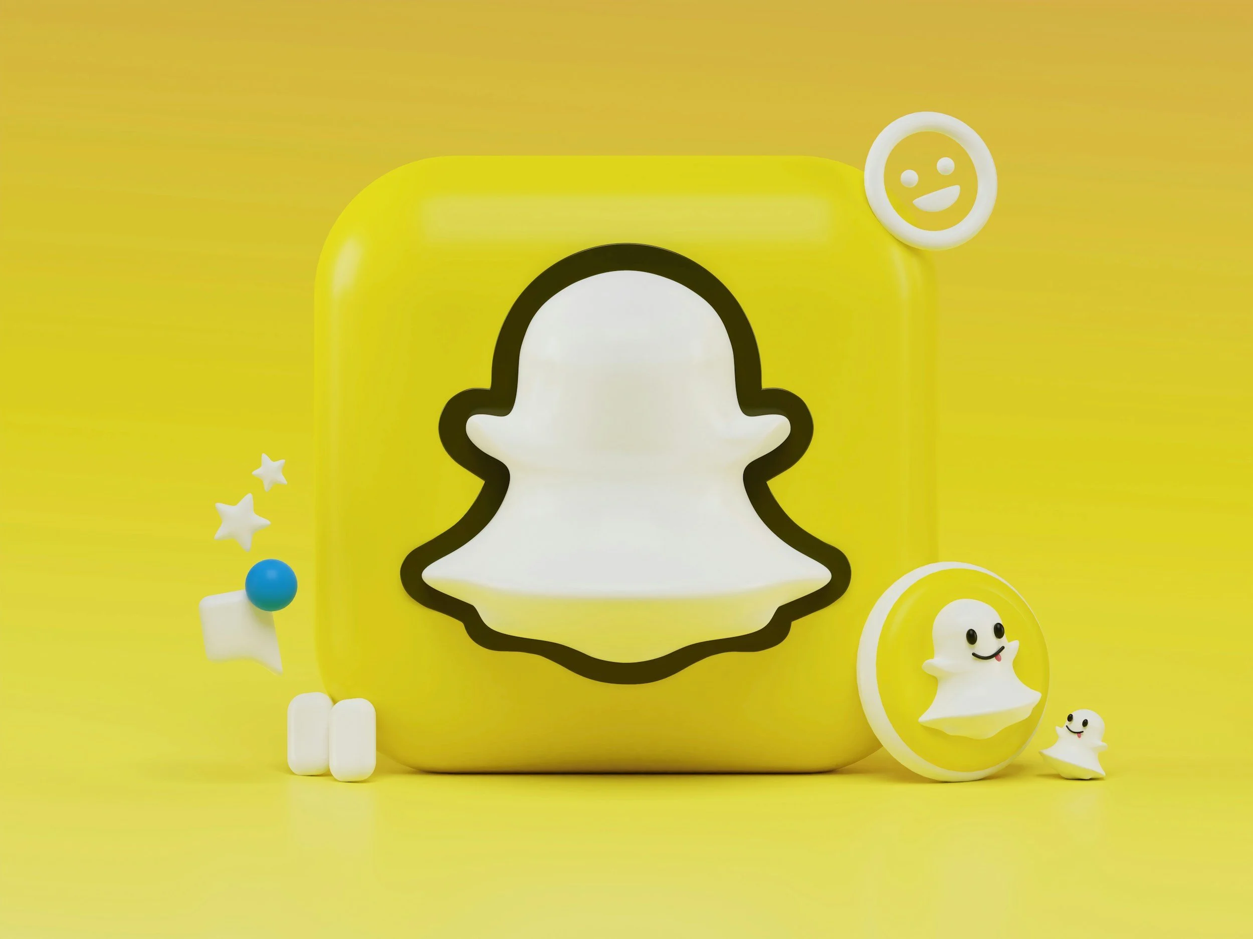 Yellow Snapchat camera with black-outlined white ghost logo, surrounded by various small white figurines with smiling faces, a blue ball, and star-shaped decorations on a yellow background.