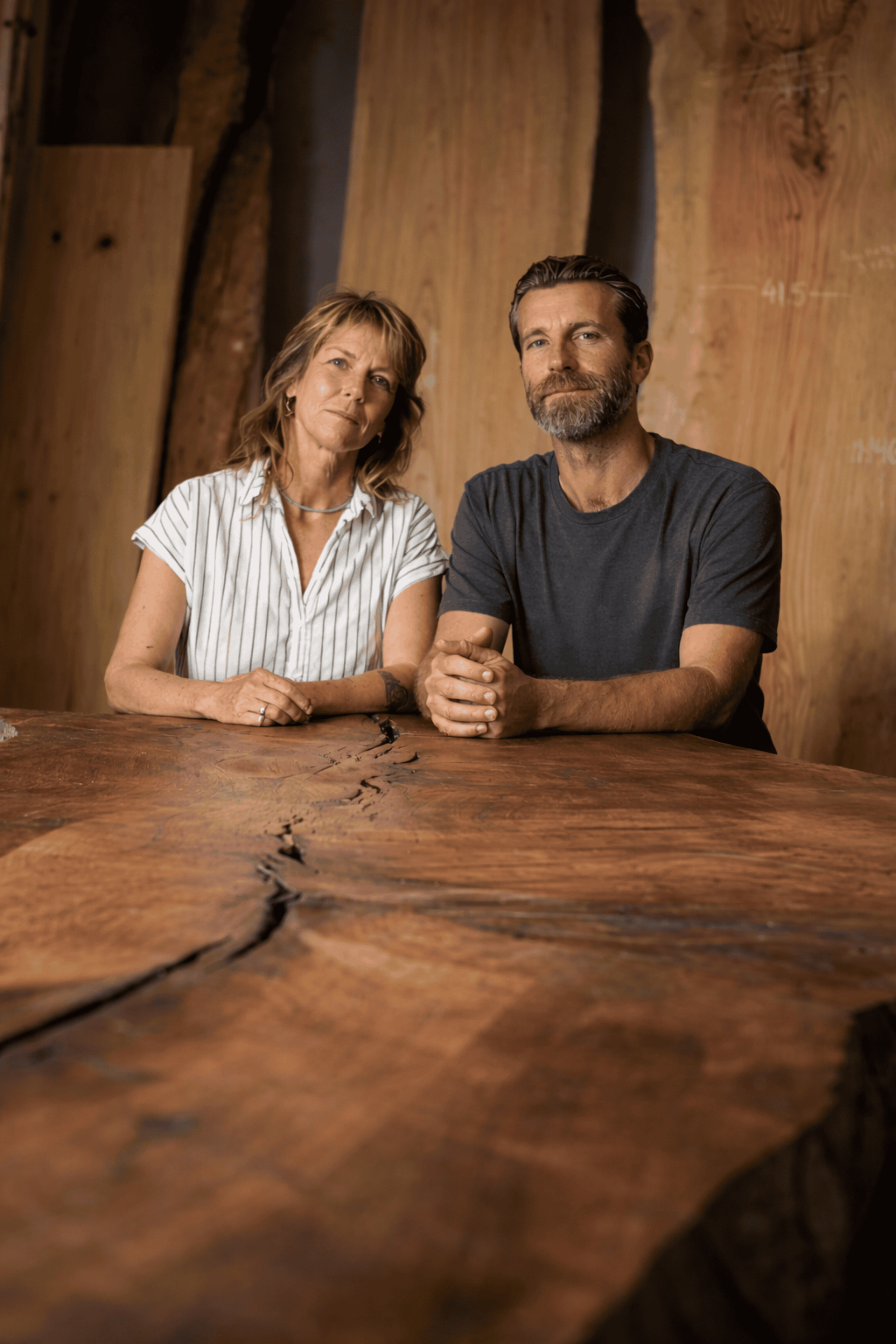 The  SD Urban Timber Founders sitting at a large wooden table with a natural finish, inside a room with wood panel walls.