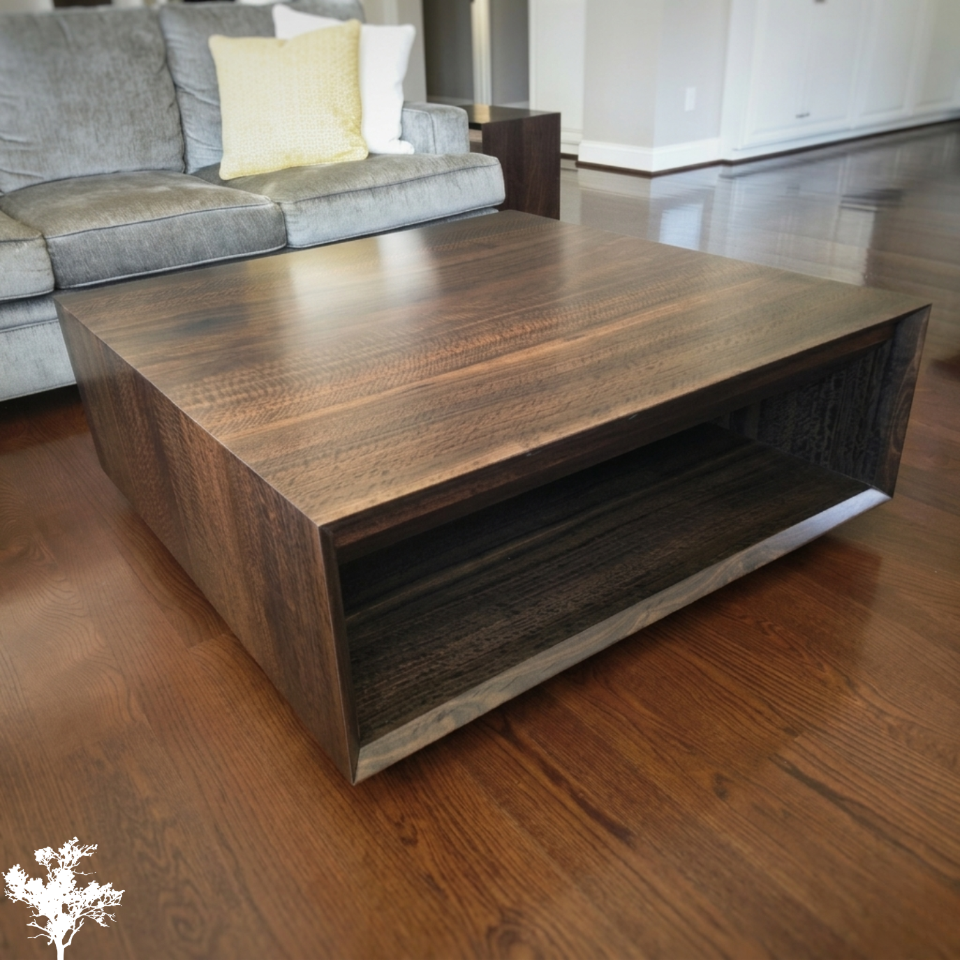 A wooden coffee table with a minimalist design in a living room with wooden flooring and a gray sofa