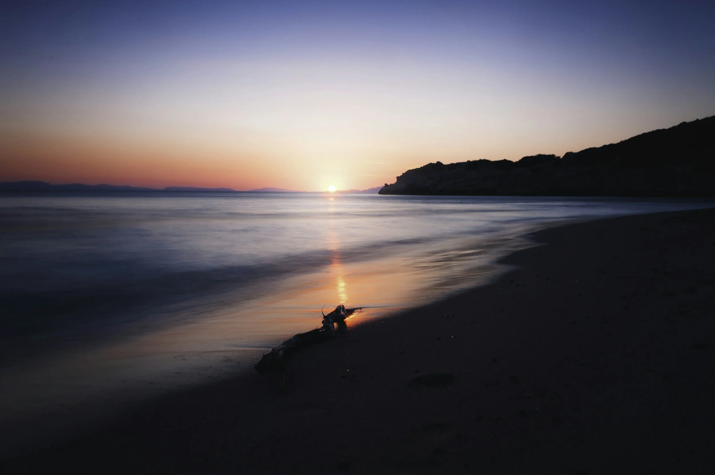 sunset over the ocean and sand