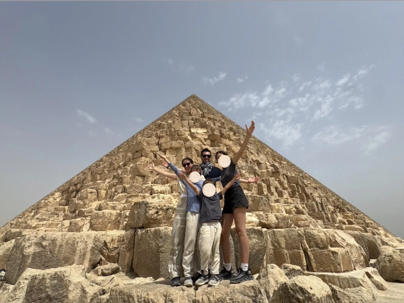 Family standing in front of the pyramids of giza