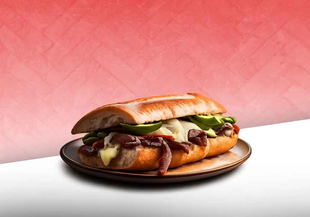 Philly cheesesteak sandwich with beef, melted cheese, peppers, and onions on a bun